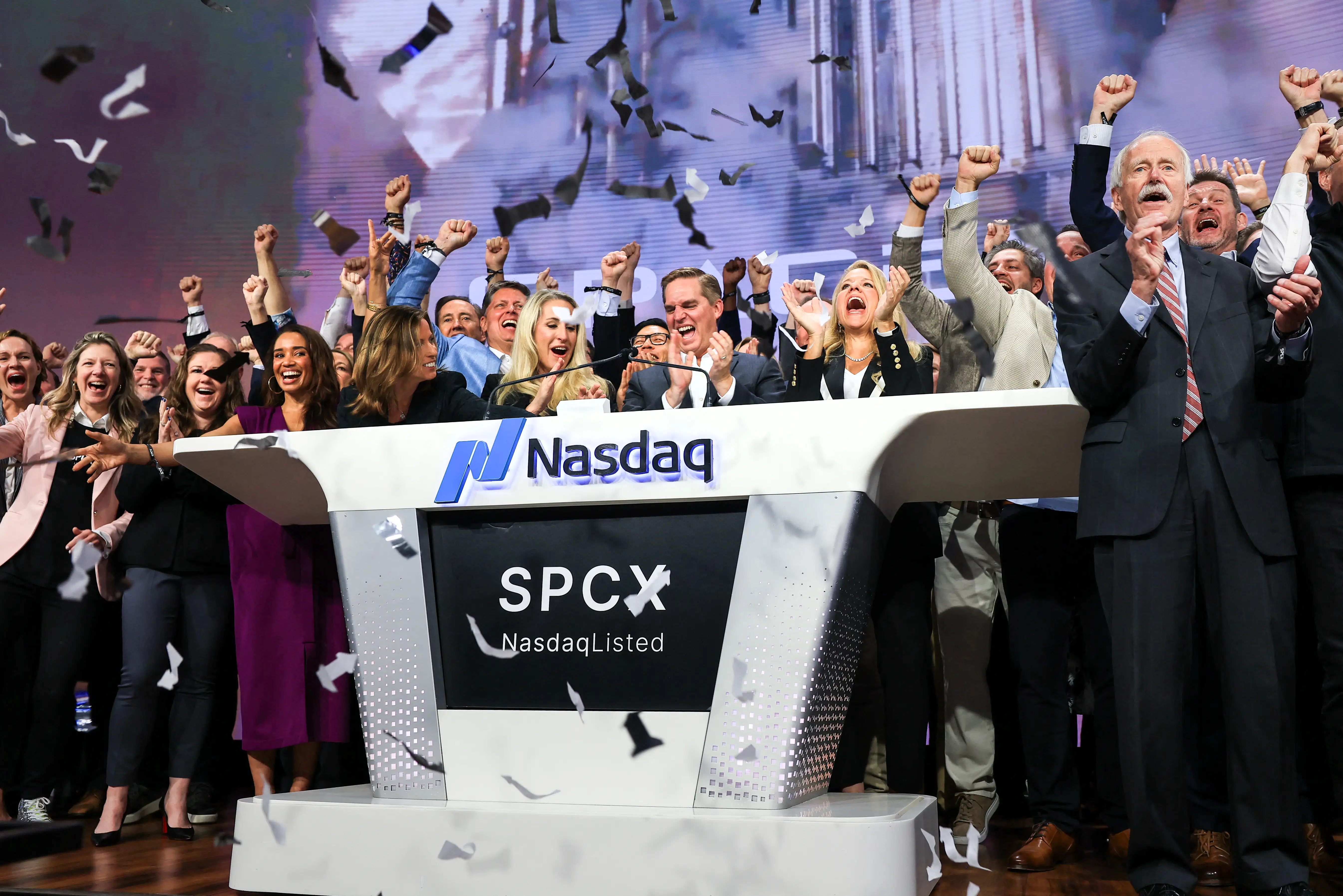 SpaceX Chief Financial Officer Bret Johnsen in the center and President Gwynne Shotwell to his right celebrate as they ring the opening bell at the Nasdaq MarketSite to celebrate the launch of SpaceX's initial public offering.