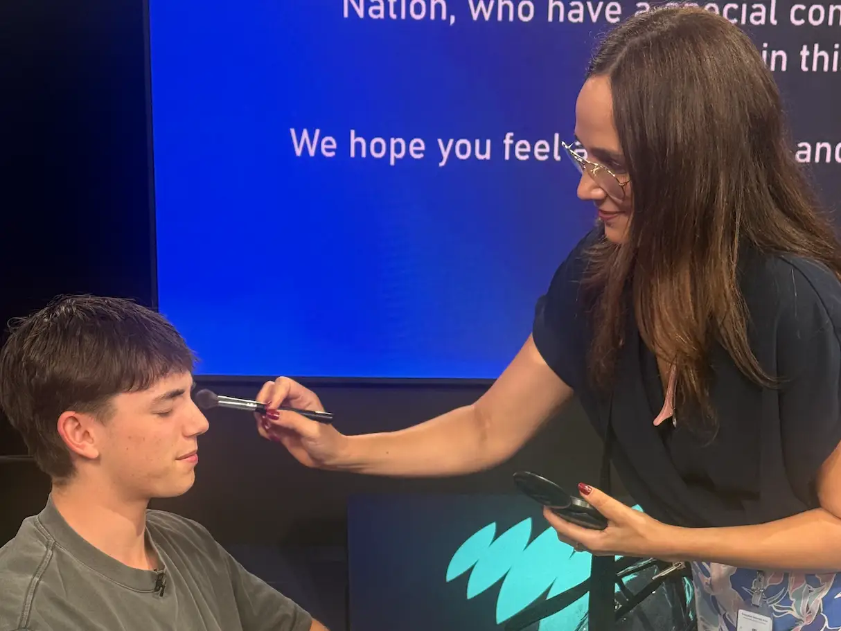 Young man getting makeup on for TV