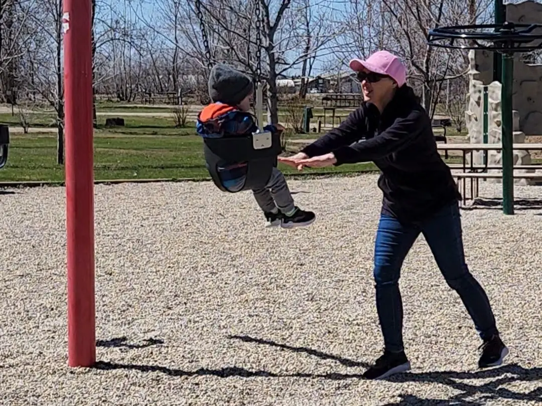 Grandma pushing baby in a swing
