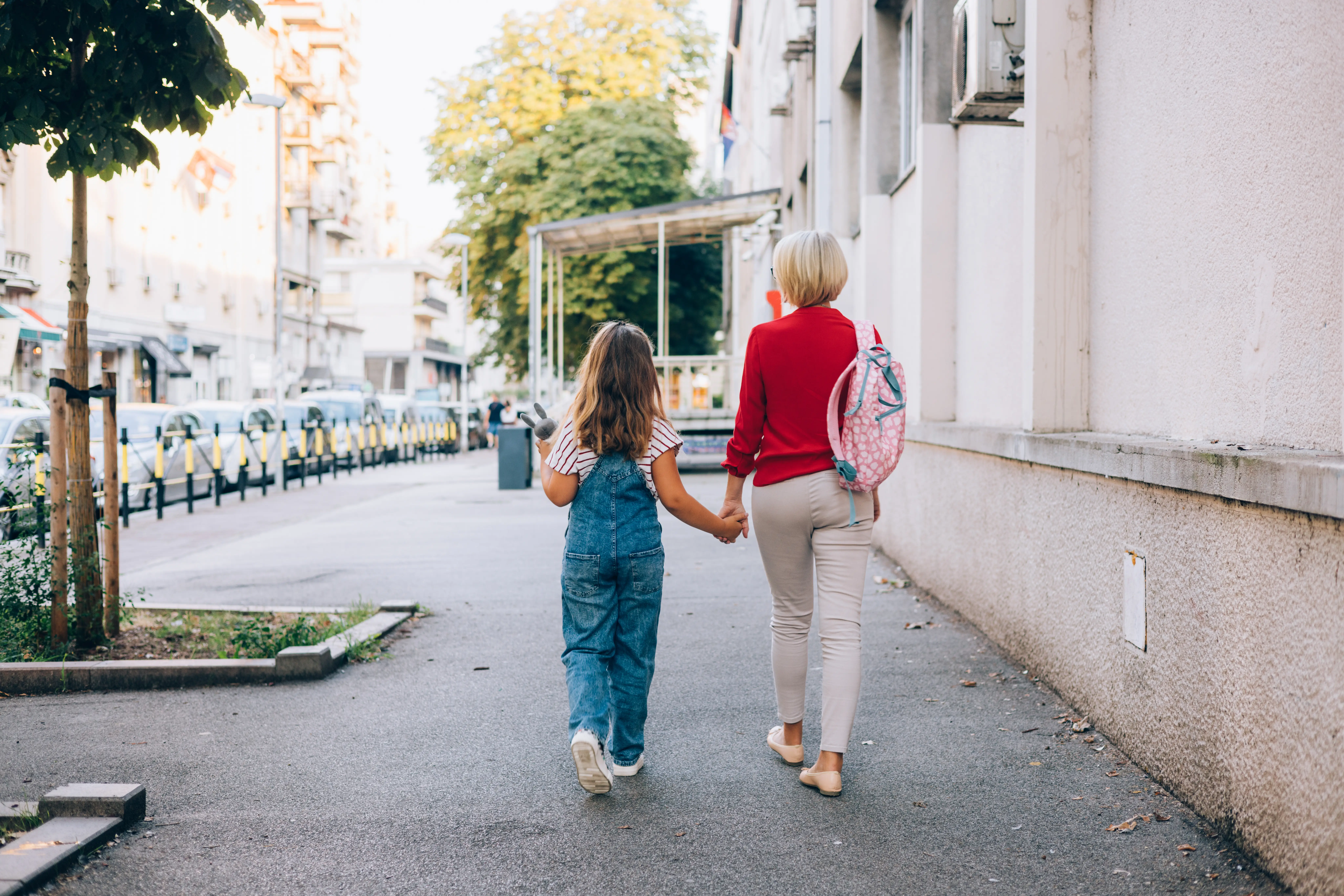 An older woman and young girl walk together on a city street