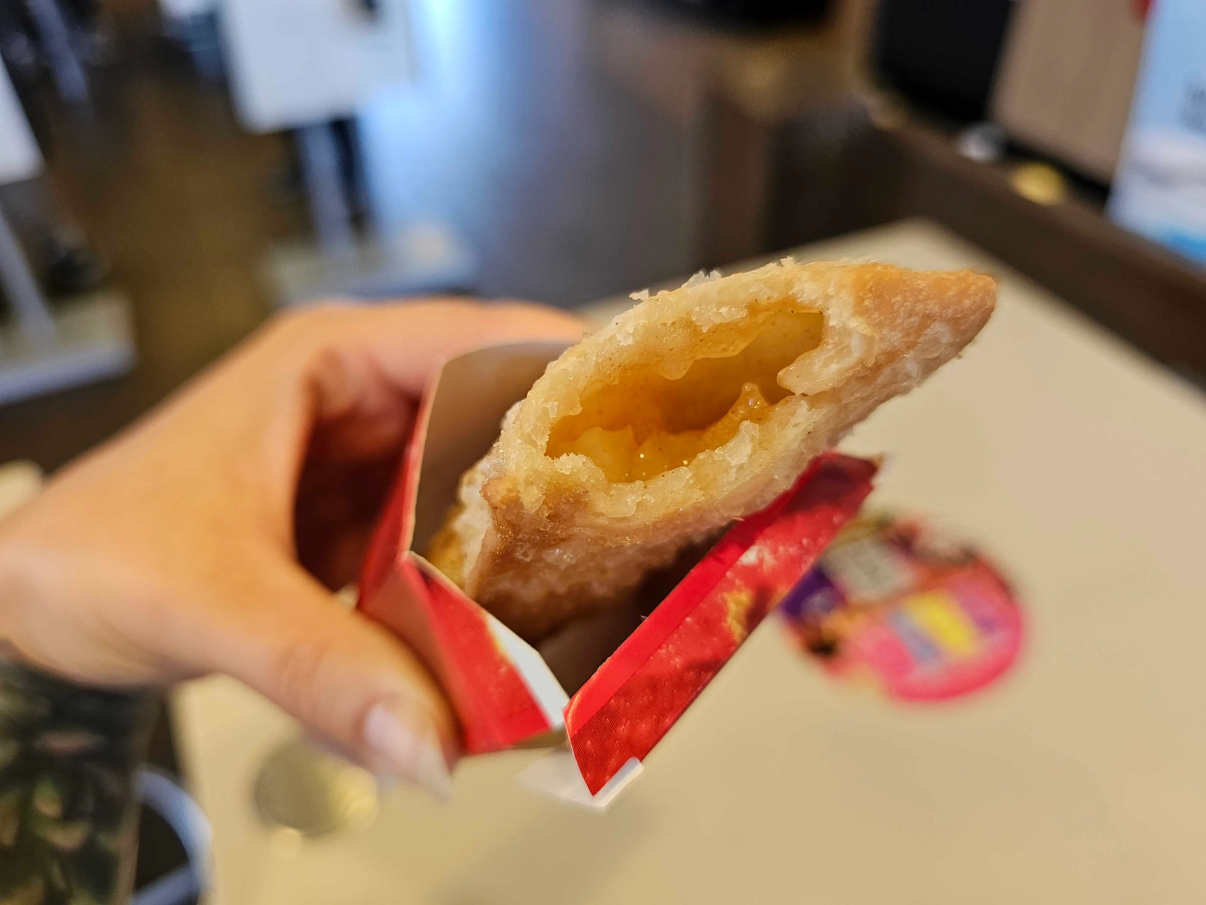 A McDonald's fried apple pie with a bite taken out of it, showing the filling