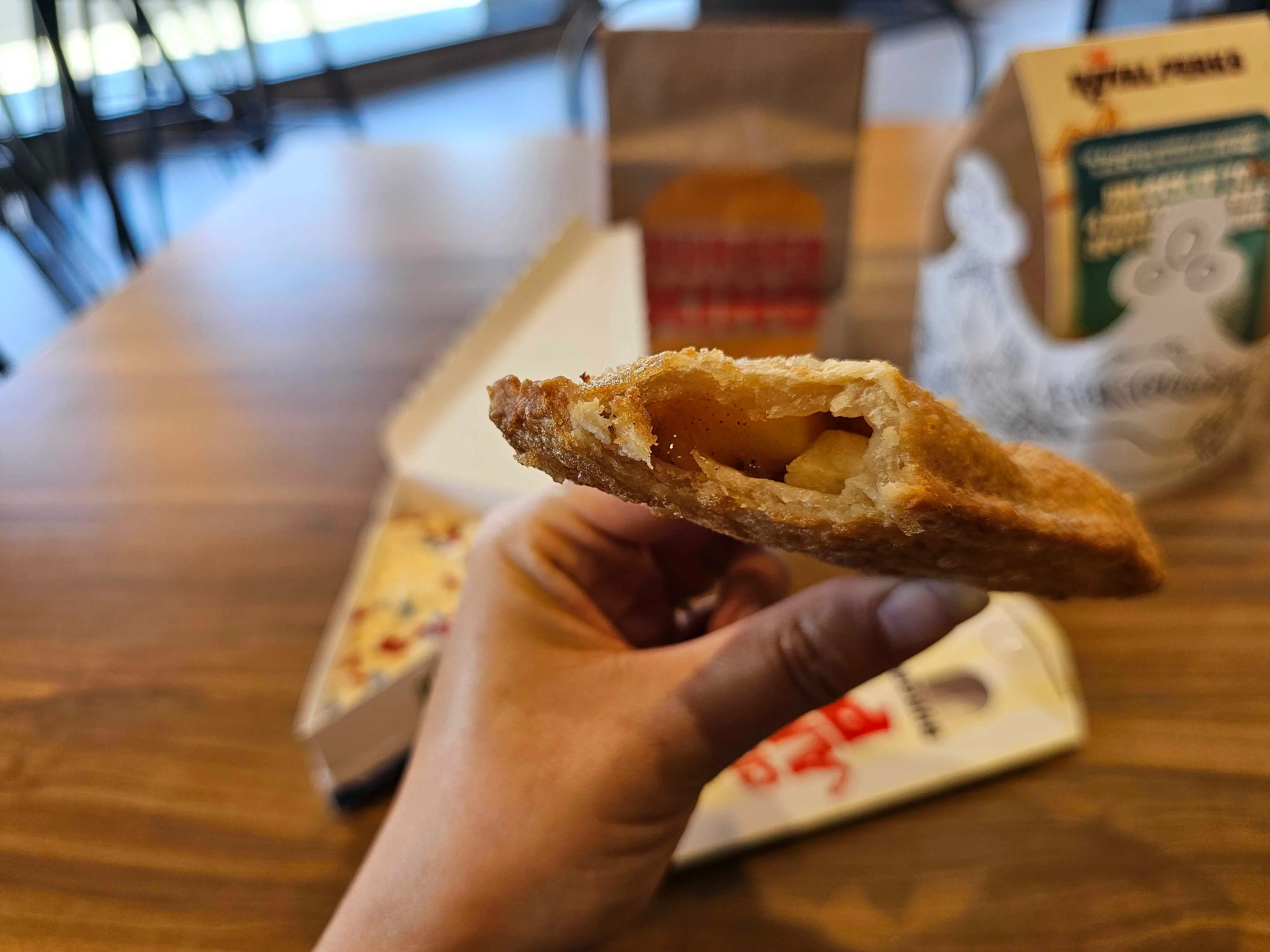 A Burger King cinnamon apple pie with a bite taken out of it