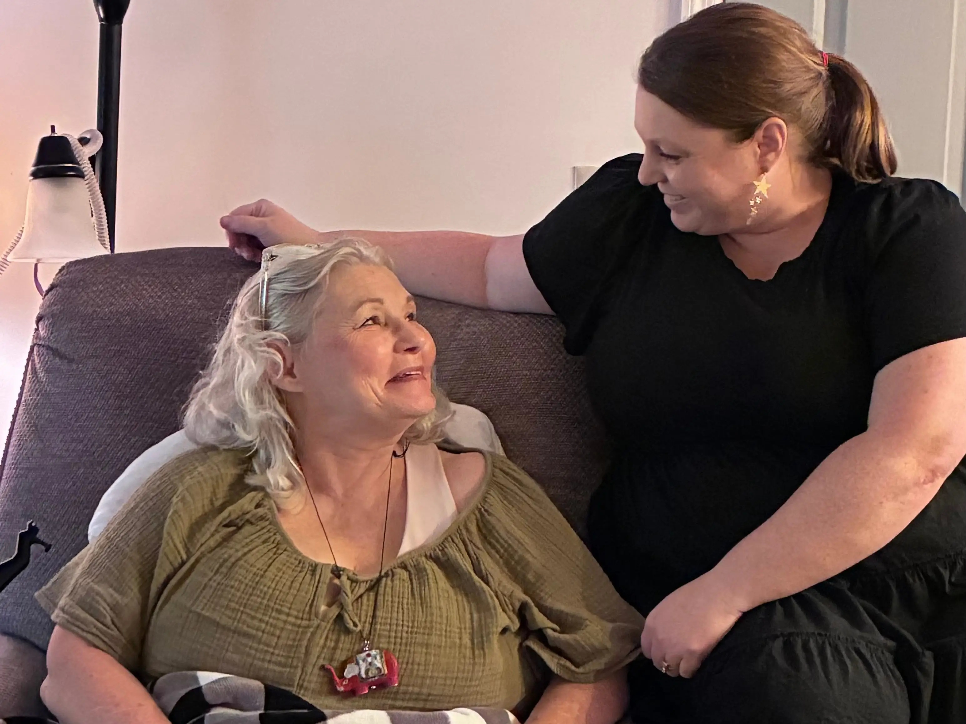 A woman in a reclining chair with her daughter next to her.