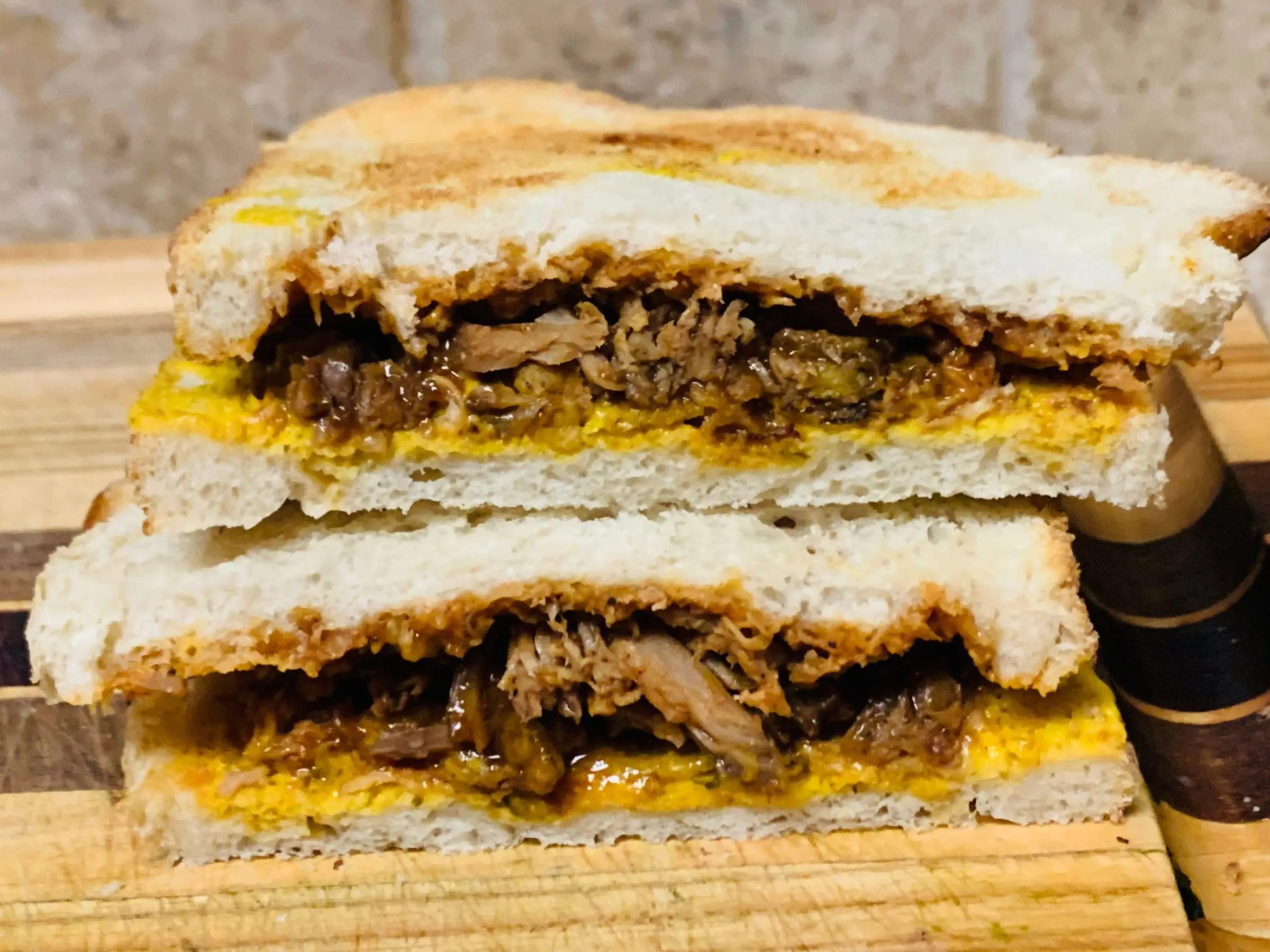 A pulled chicken sandwich with Trader Joe's dill-pickle mustard on it.