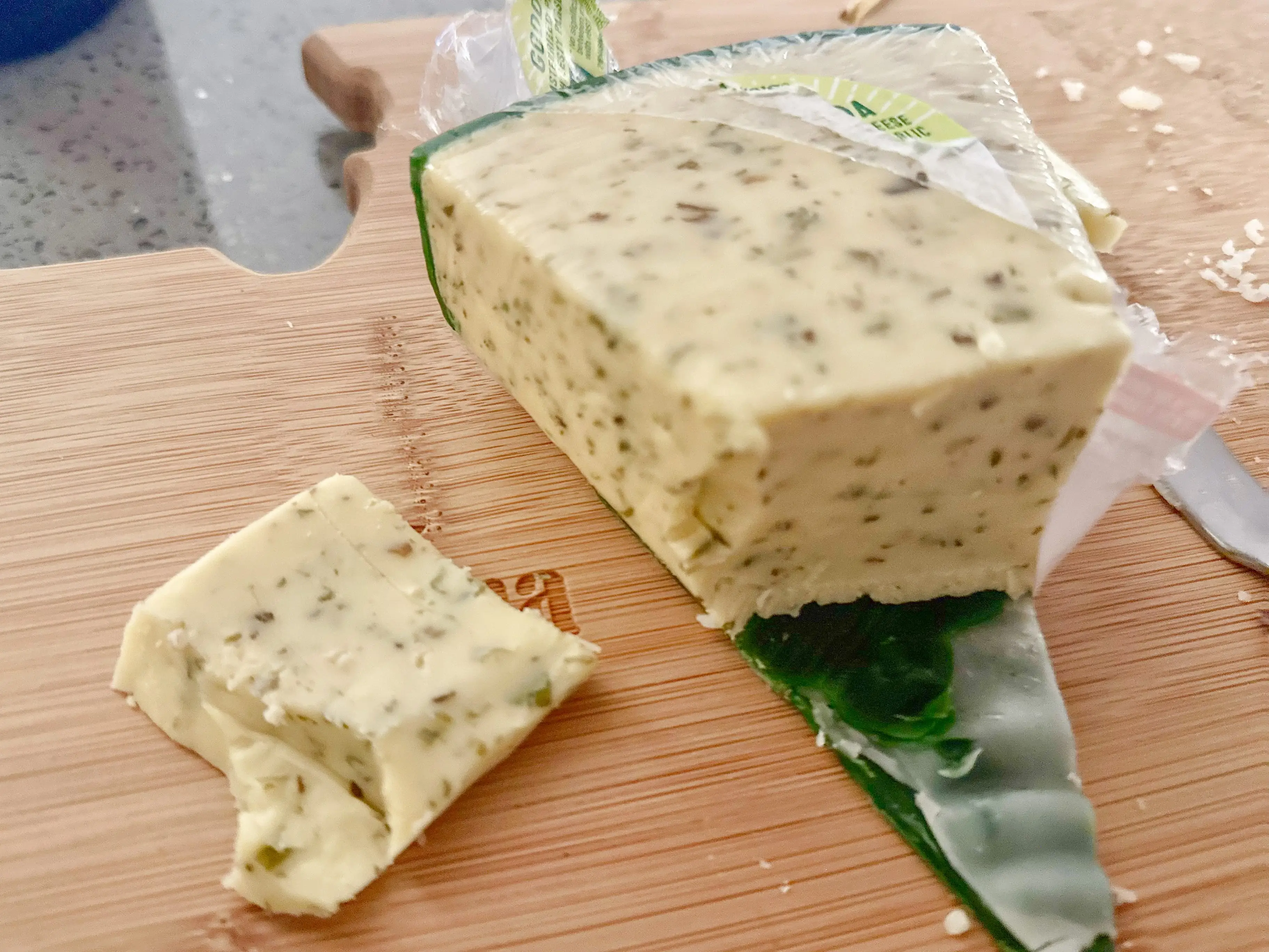 An open package of Trader Joe's Green Goddess Gouda, with a piece sliced off.