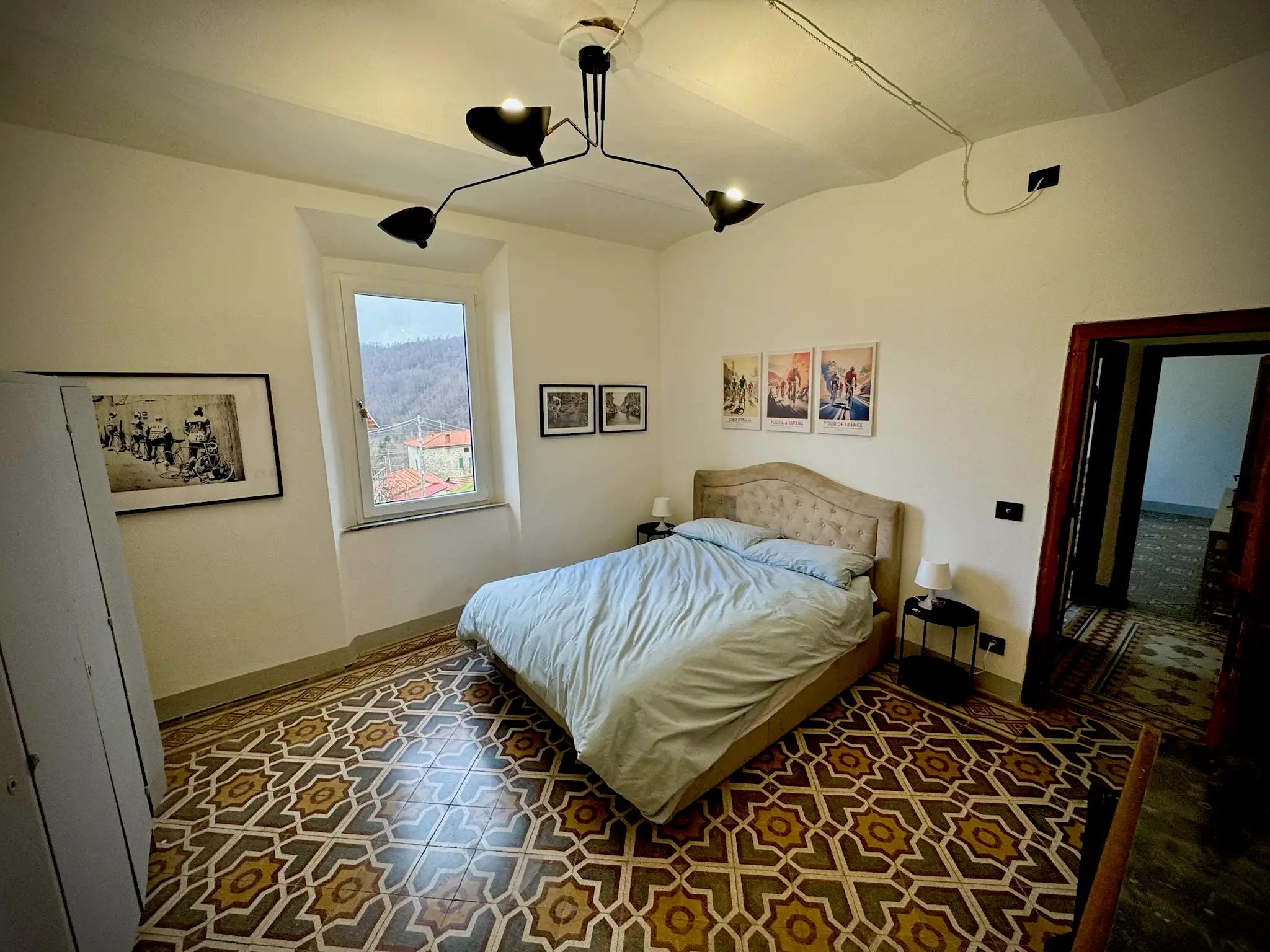 Bedroom with patterned tiled floor, white walls