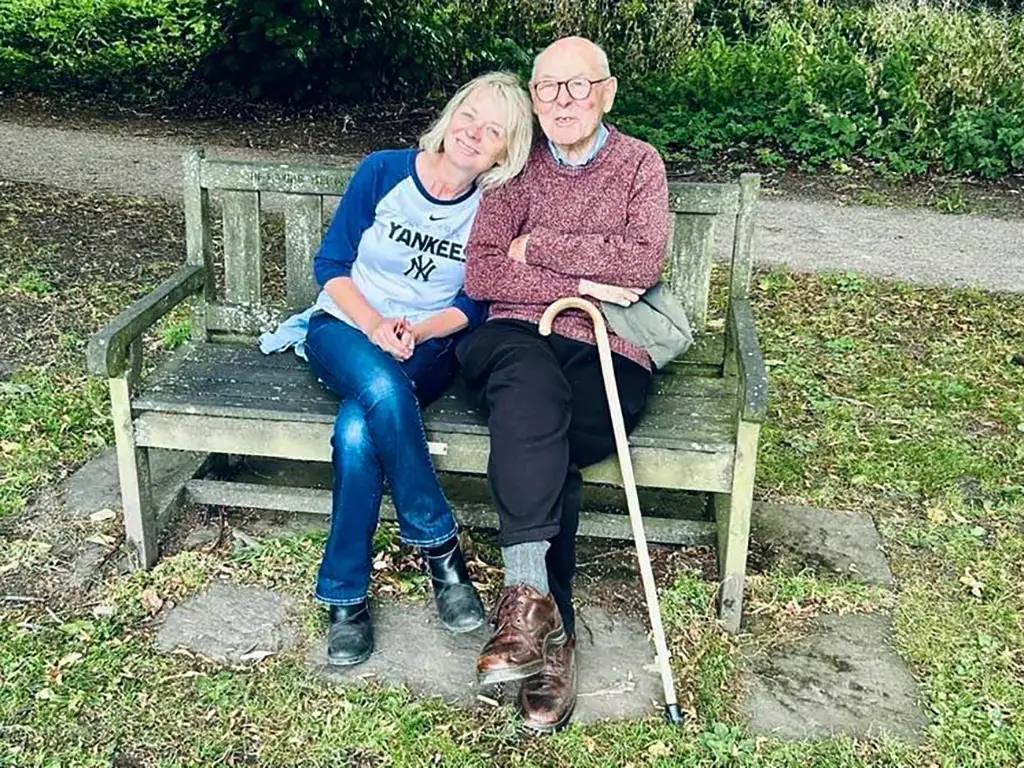 A woman resting her head on an older man's shoulders.