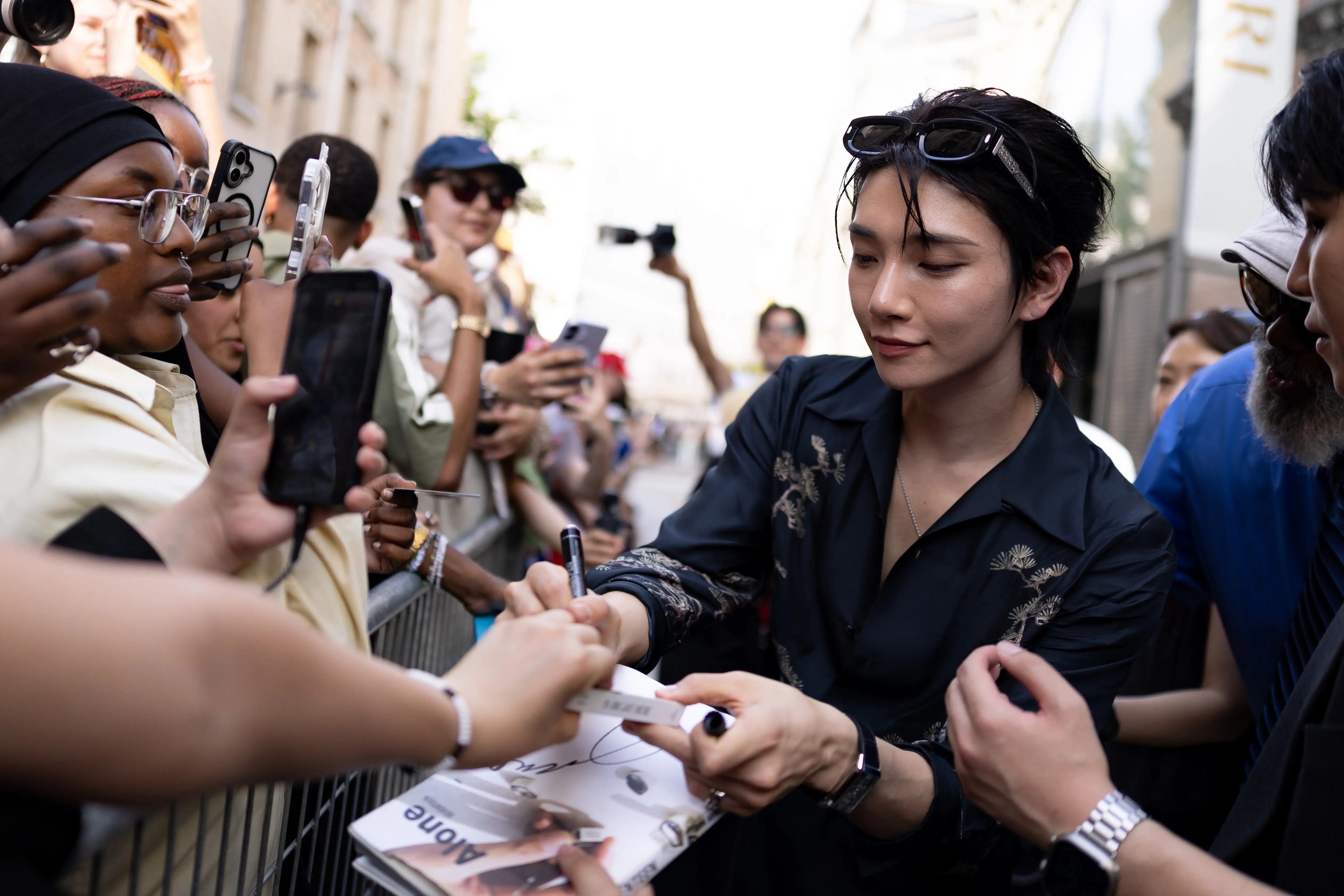 Joshua Hong signs autographs for fans at Paris Fashion Week