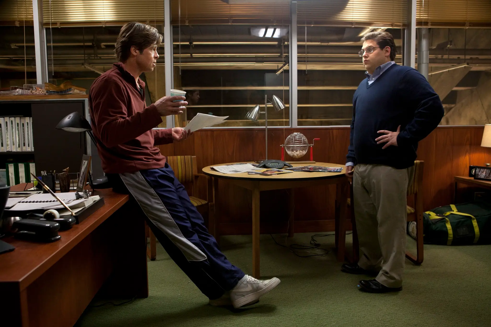 Brad Pitt and Jonah Hill standing in an office in Moneyball movie