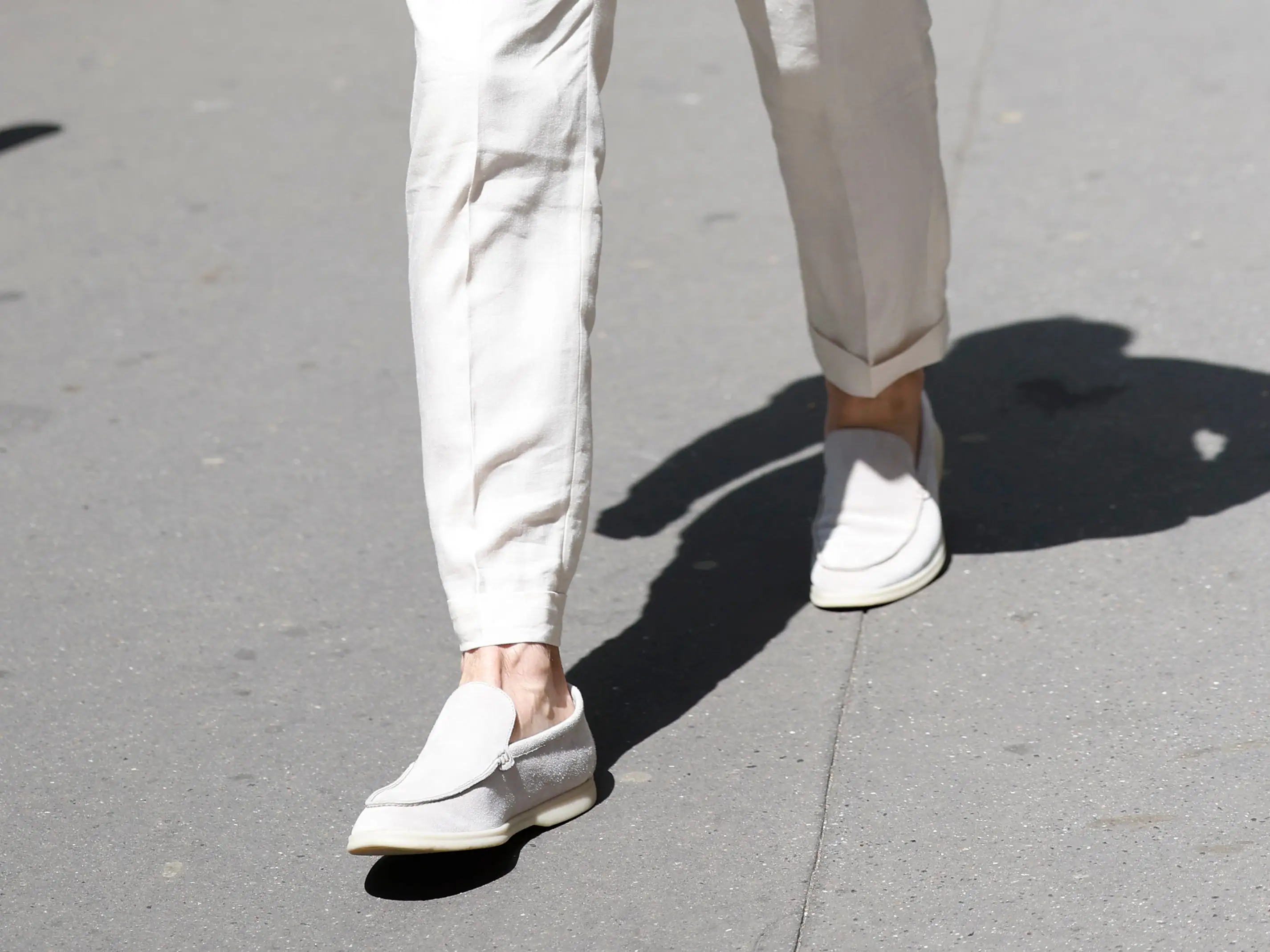 Johannes Huebl wears white shirt, cream suit, brown sunglasses, white Loro Piana suede loafers, outside Hermes,