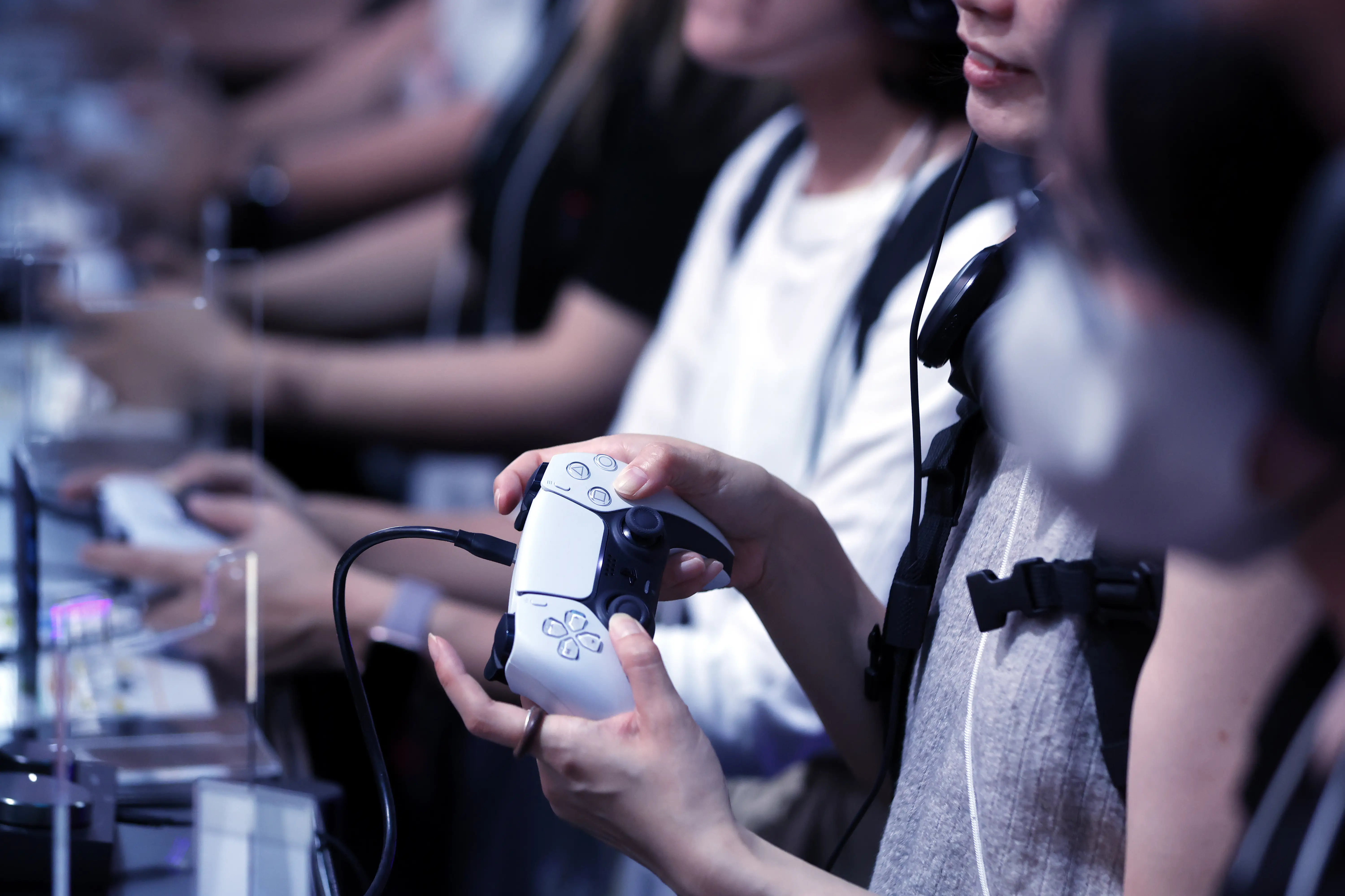 A person uses a Playstation controller at a gaming conference in Japan.