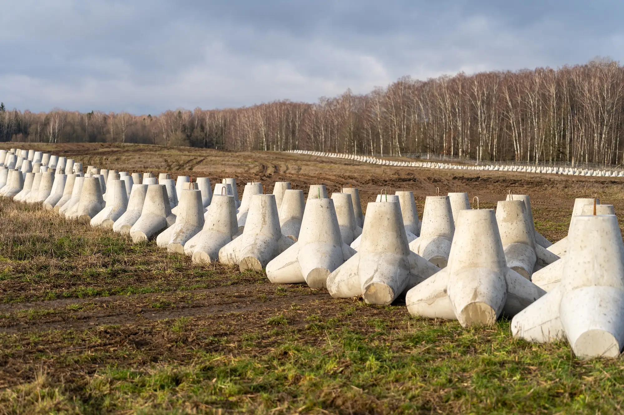 A section of Poland's border with Russia is laid with anti-tank obstacles, seen here in 2024. But along a farm nearby, the only obvious protection is a simple concertina-wire fence.