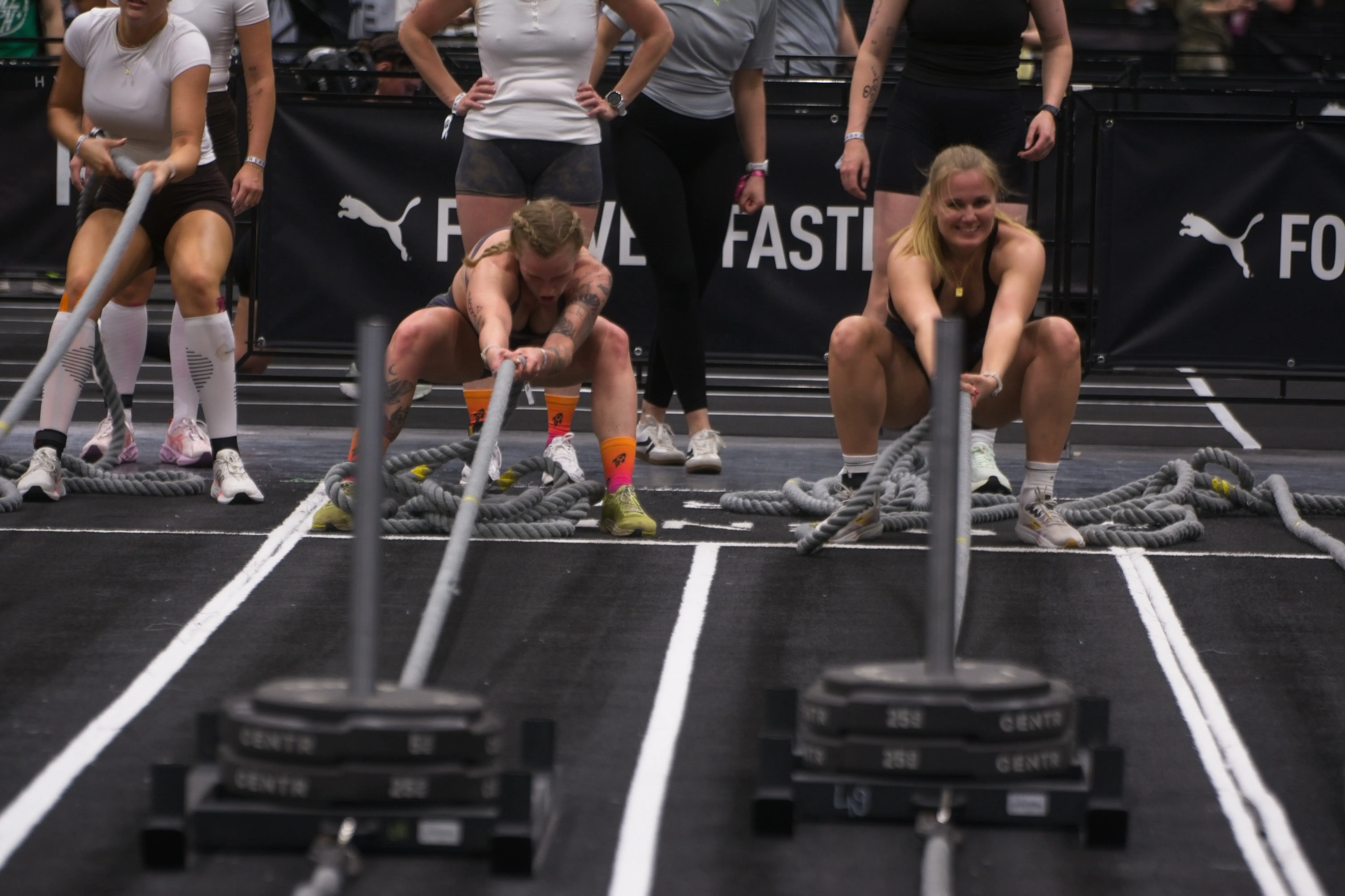 athletes pulling a weighted sled during a Hyrox competition