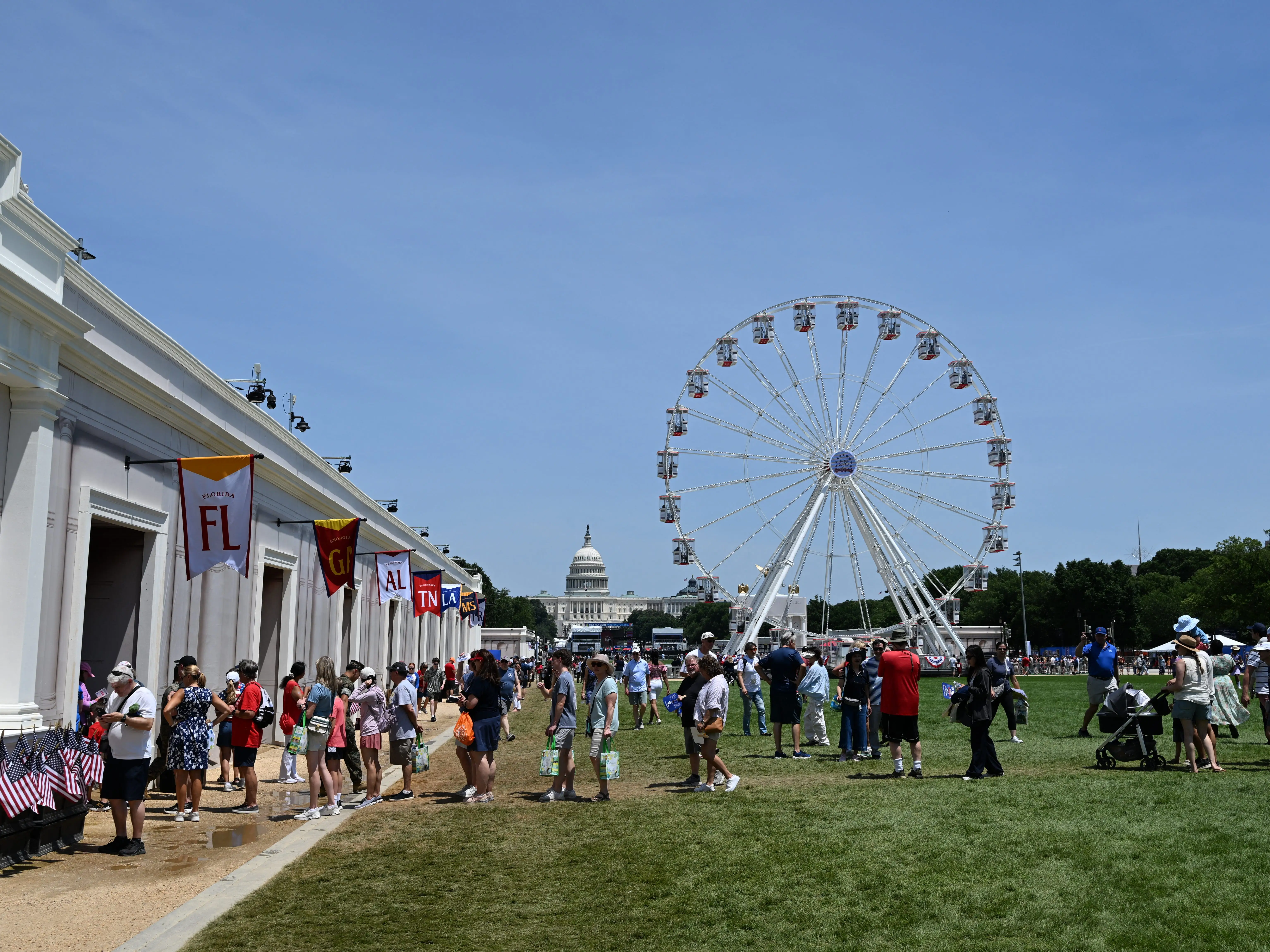 People at the Great American State Fair with a ferris wheel and the capitol in the background.