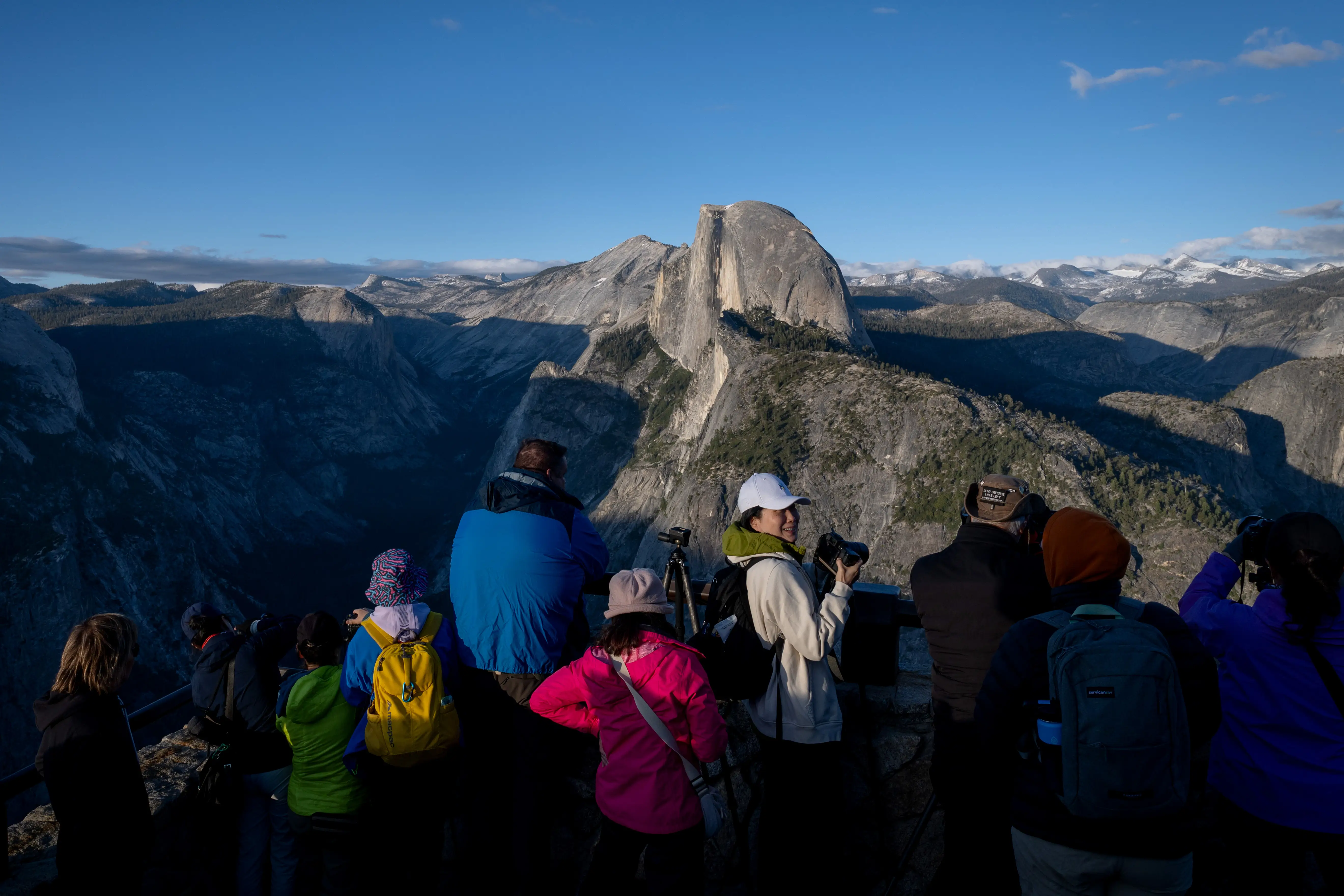 People gather at Glacier Point to watch the sun set over Half Dome in Yosemite National Park