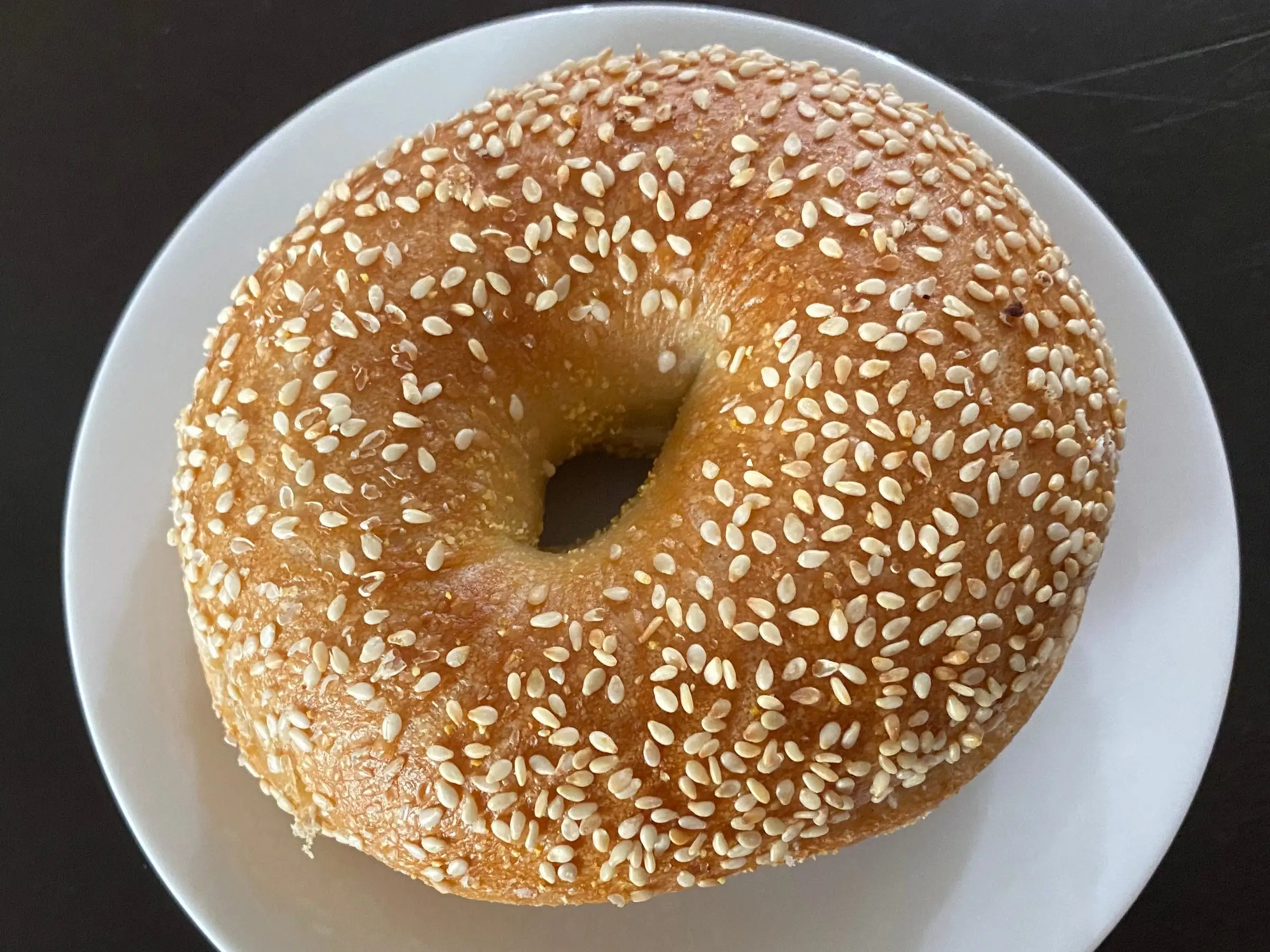 sesame seed bagel on plate from Einstein Bros