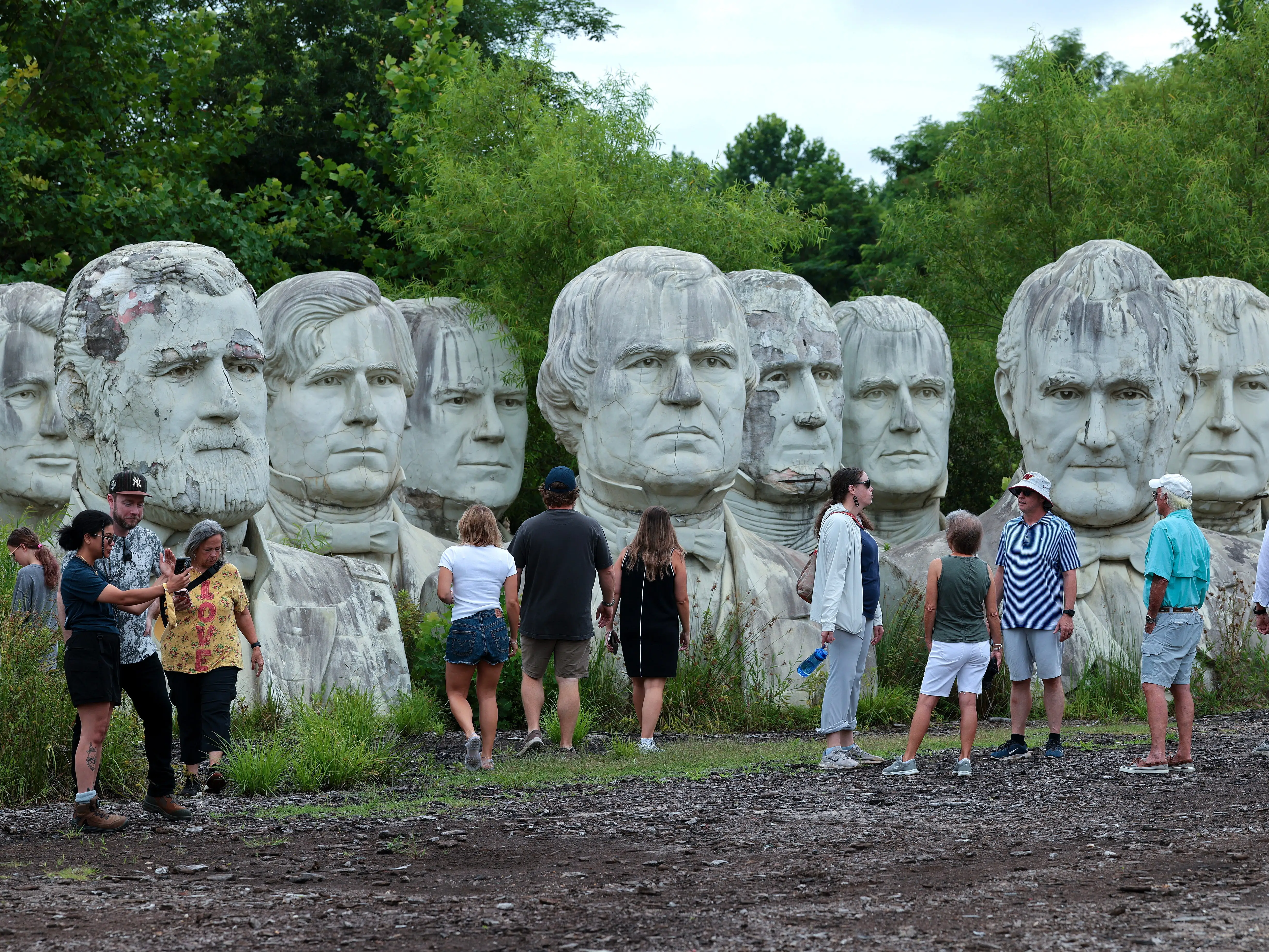 Tourists stand among the heads..