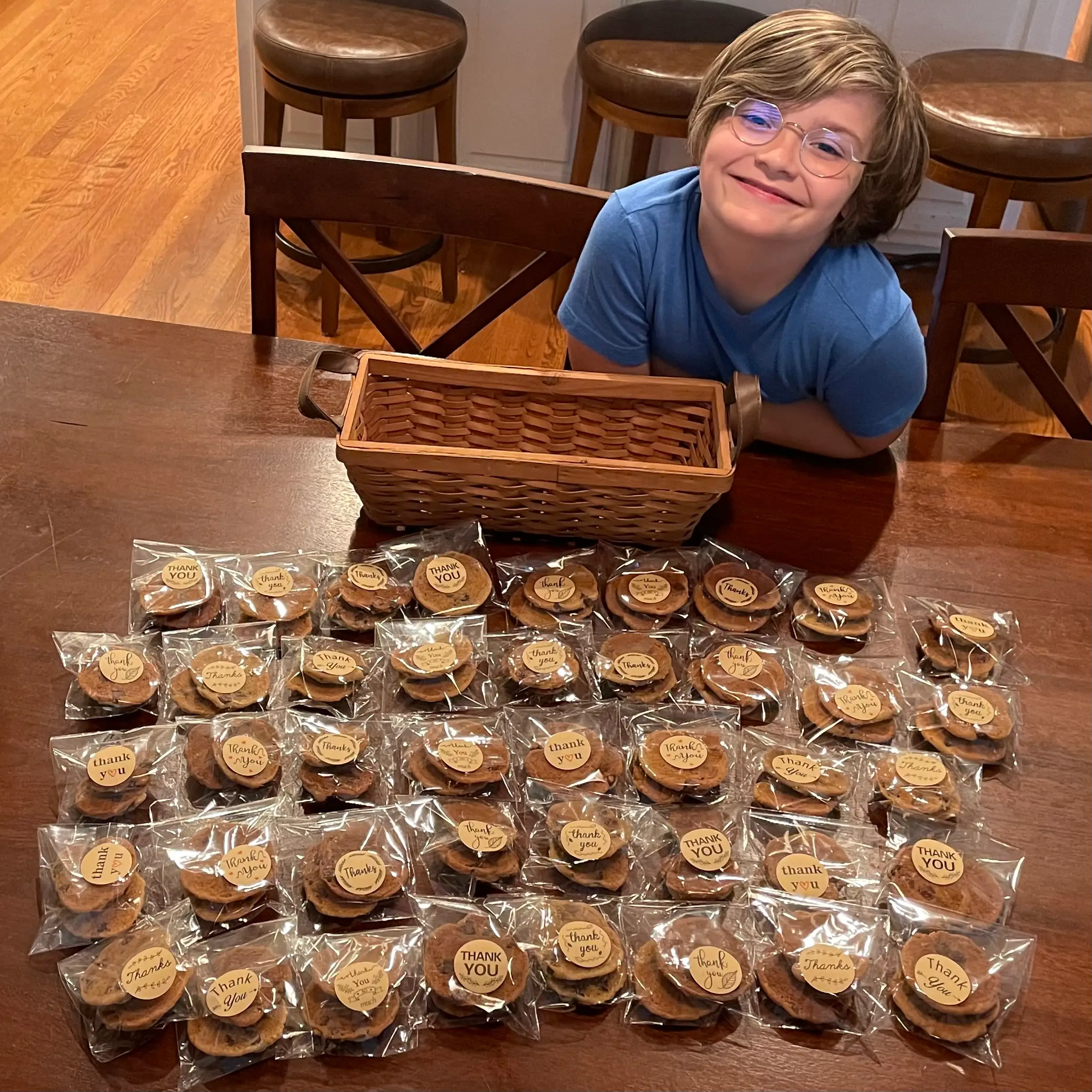 The author's son smiling next to chocolate chip cookies wrapped up for a bake sale.