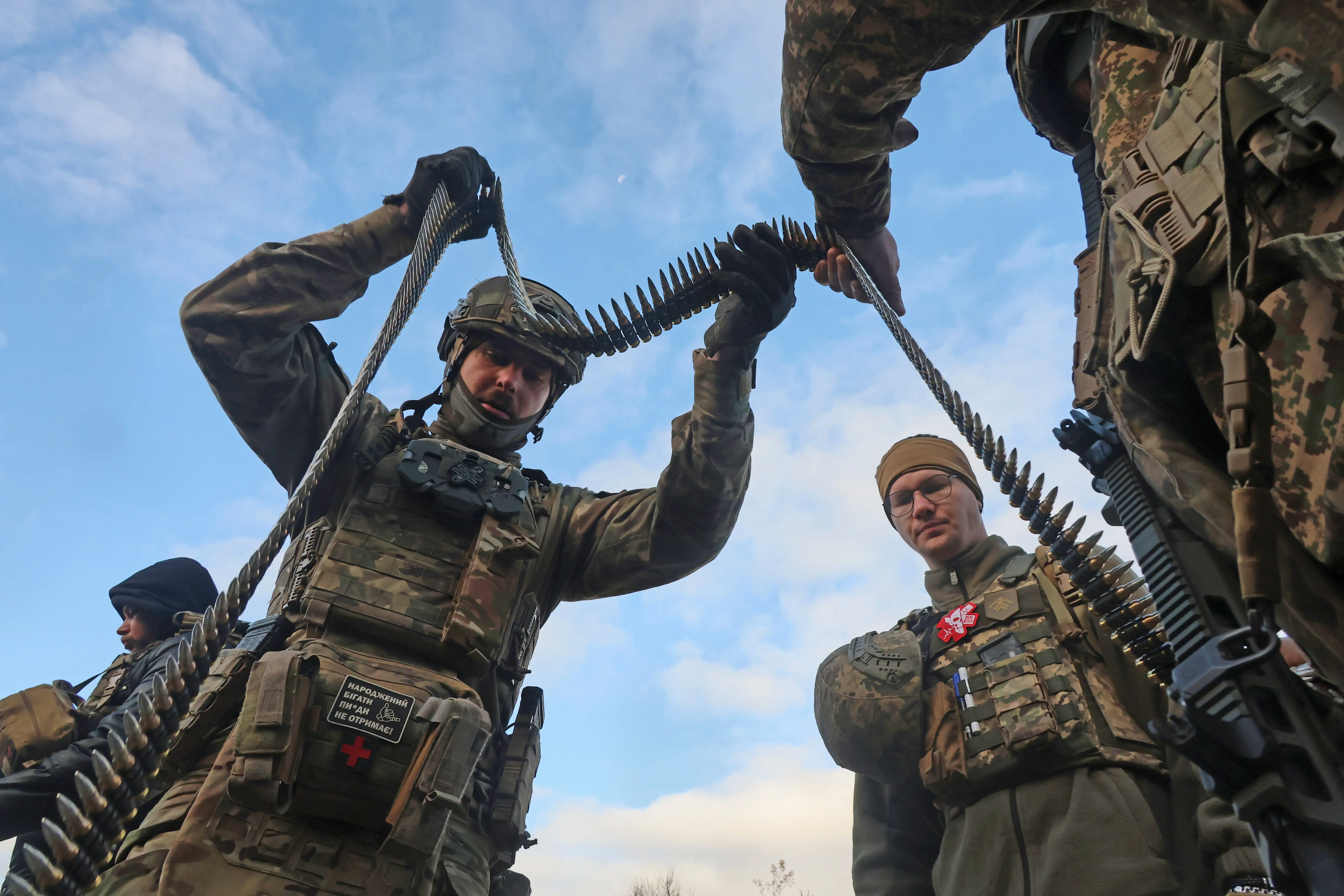 Soldiers from the 13th Khartiia Brigade of Ukraine's National Guard hold a machine gun ammunition belt during a shooting drill with weapons made in Ukraine and abroad in the Kharkiv region, Ukraine, on October 13, 2025.