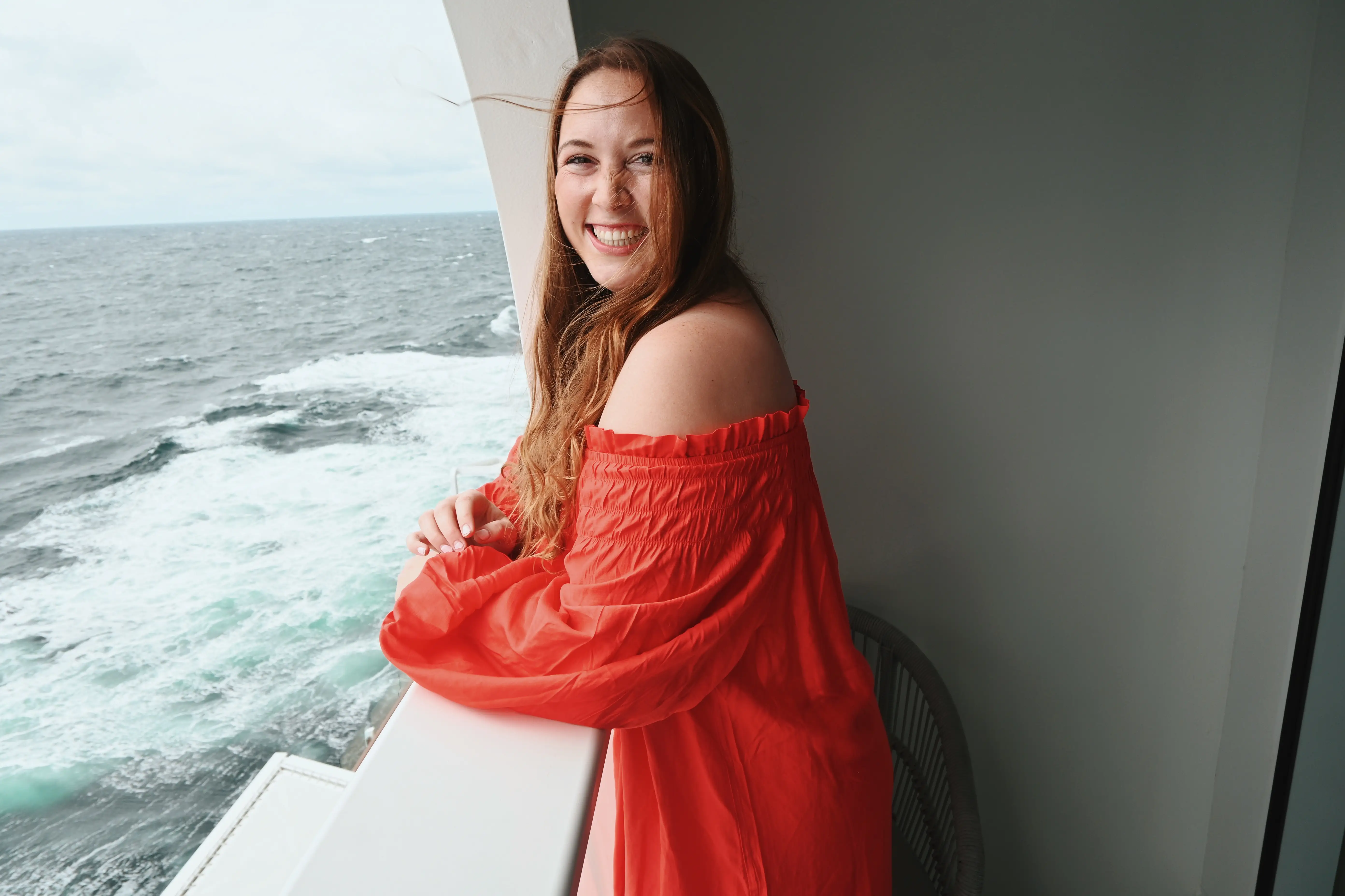 Woman, smiling, leaning over balcony on Celebrity Apex