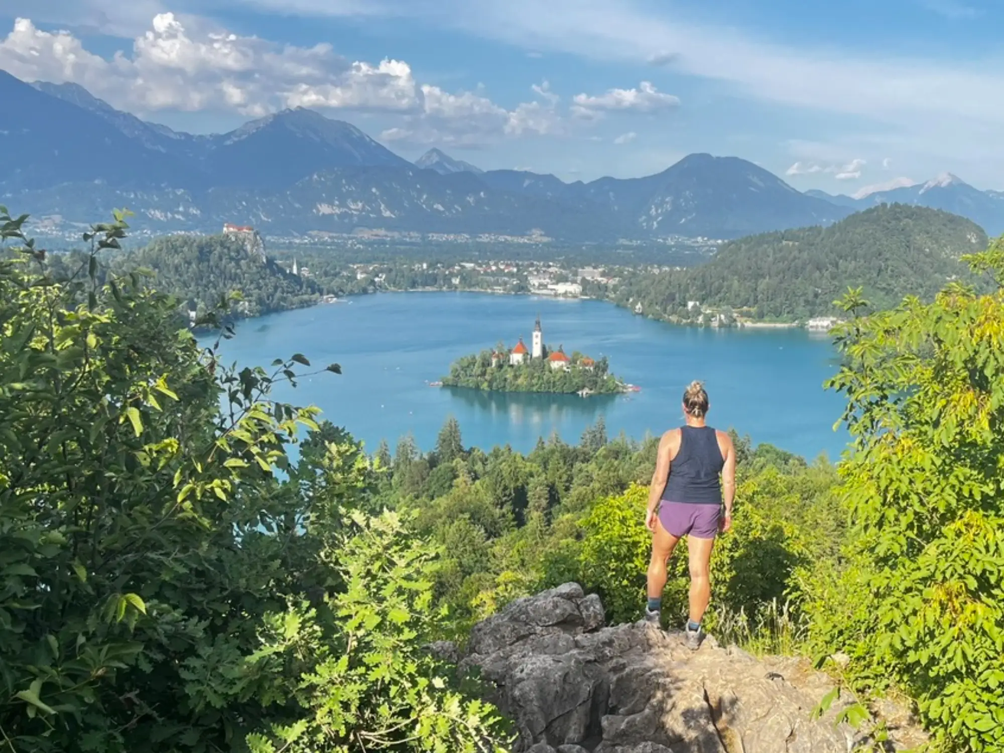 Woman standing overlooking aerial view of water, trees in Slovenia