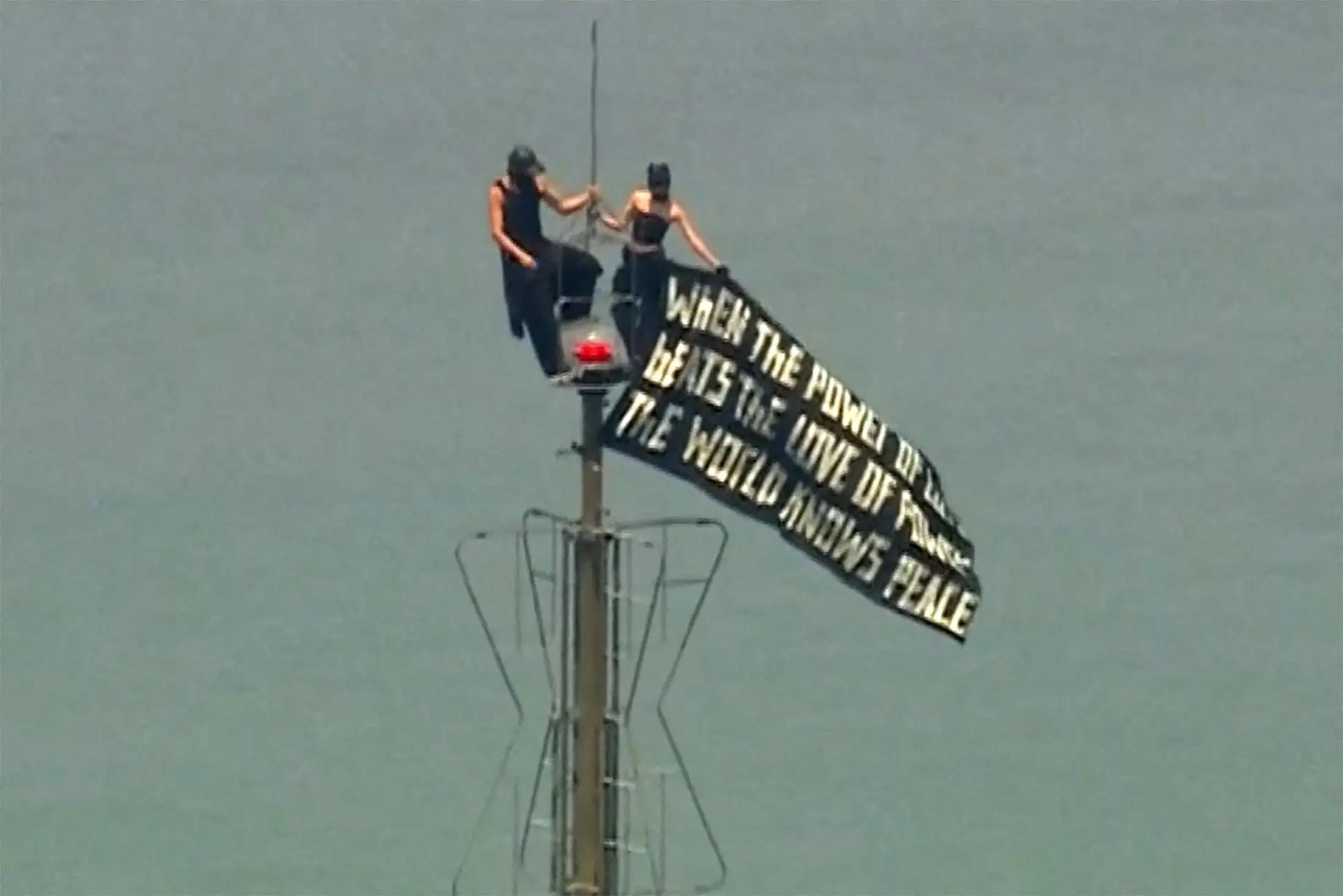 ivan beerkus and angela nikolau on the empire state buidling holding a flag