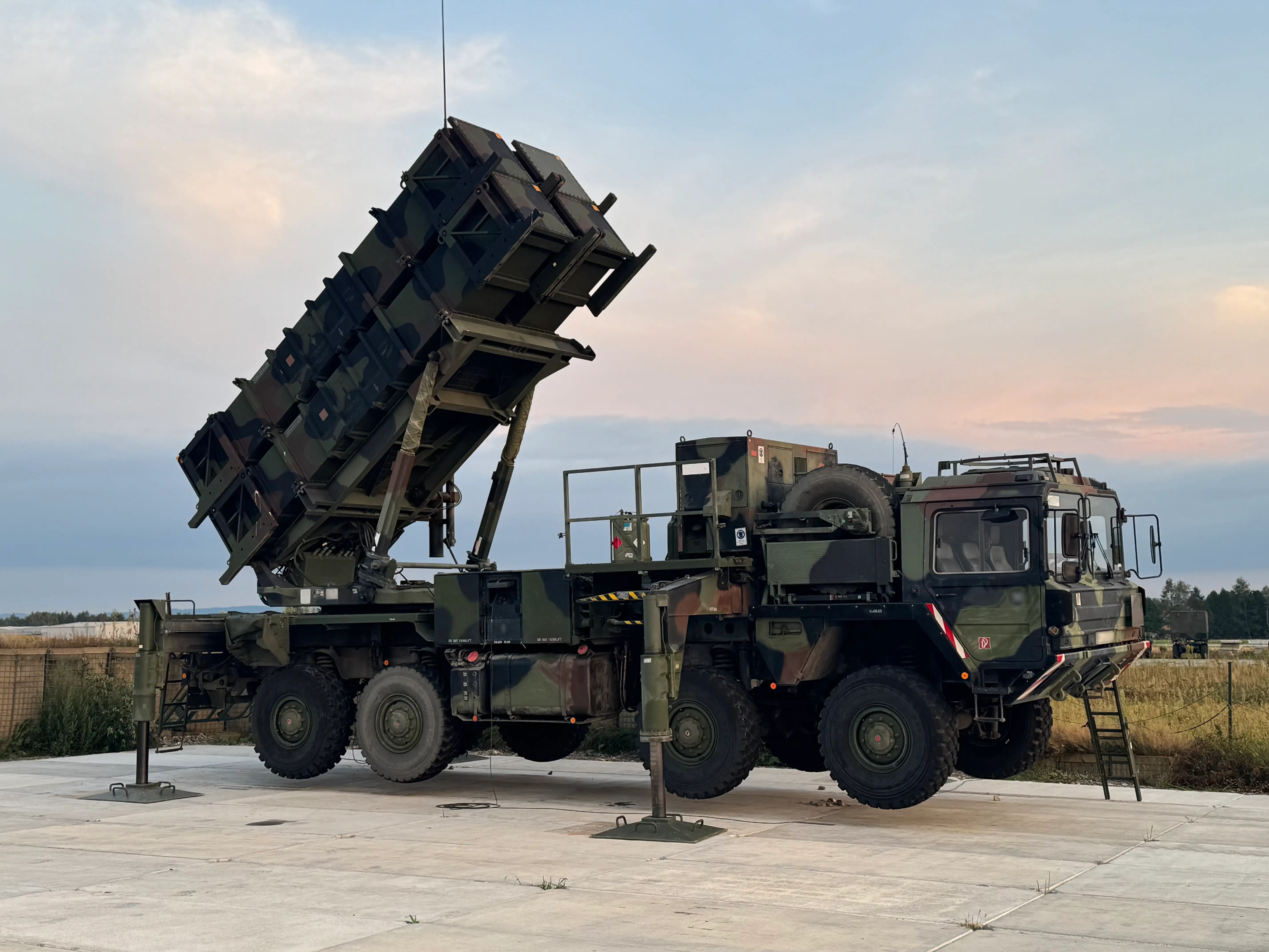 A Patriot missile system stands deployed on airport tarmac.