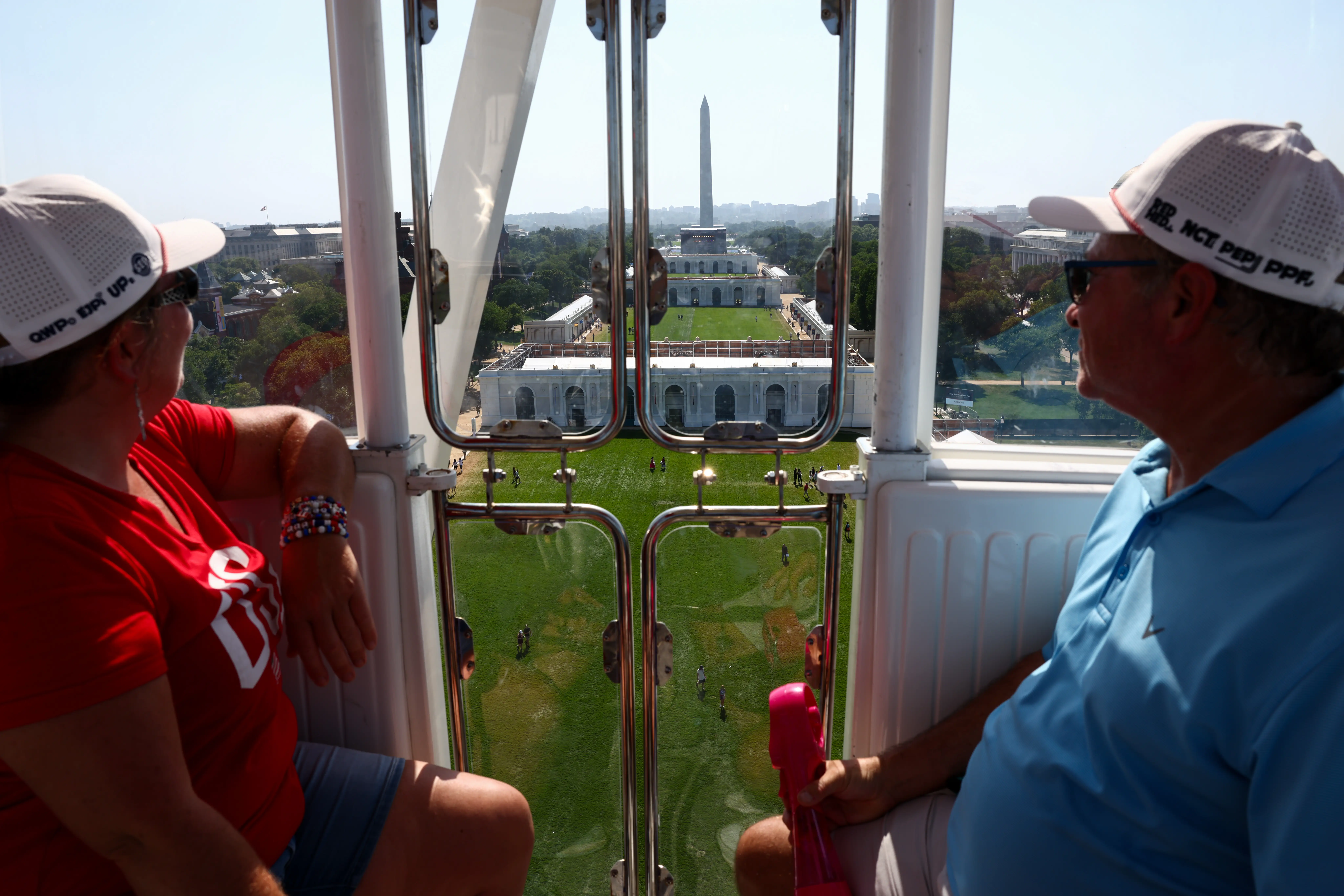 The Washington Monument is in view as Rachel and Scott Sliker, of New York, ride the Freedom 250 Ferris wheel during The Great American State Fair on the National Mall on July 02, 2026 in Washington, DC.