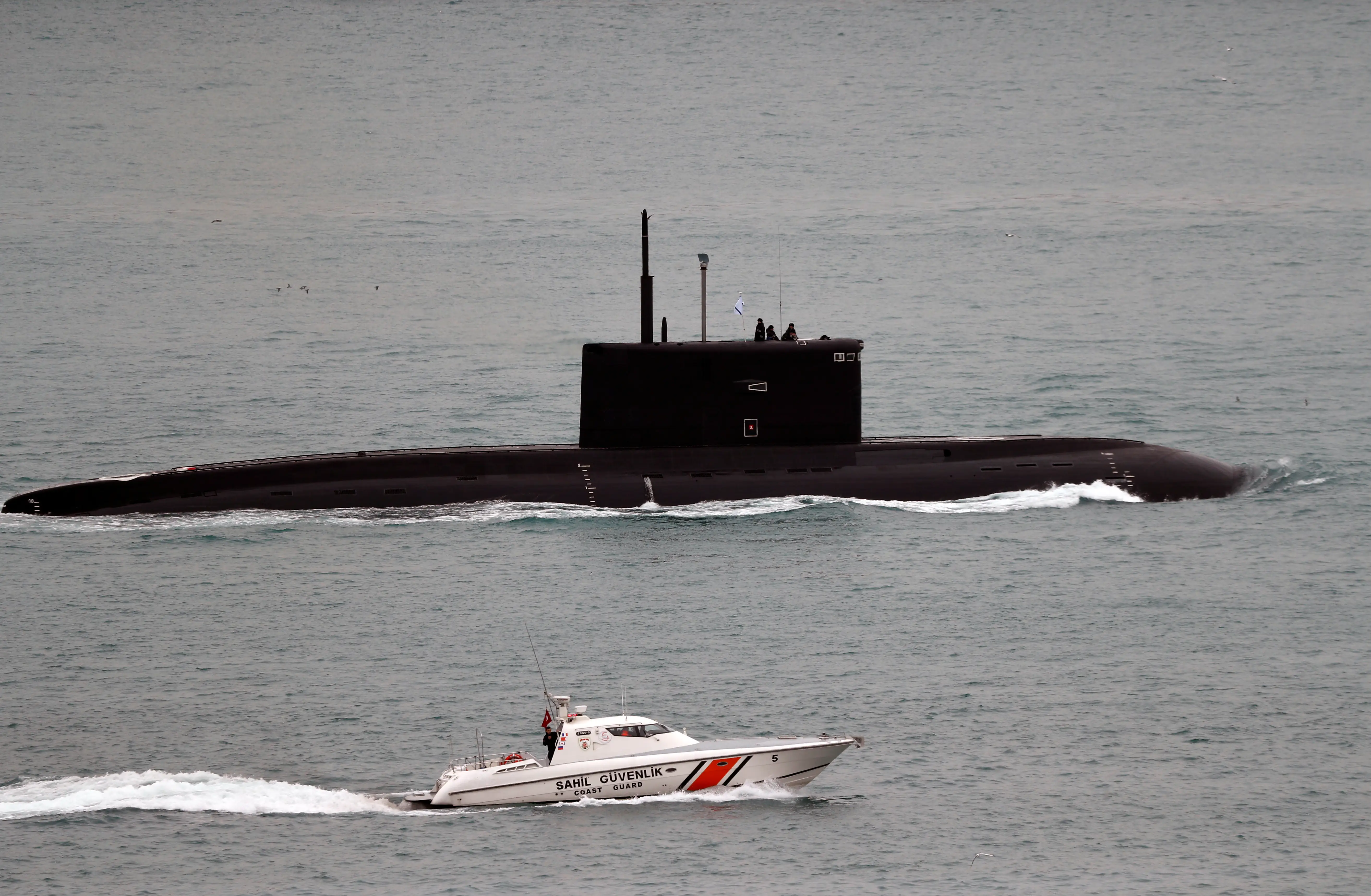 A Turkish Coast Guard boat escorts Russian Kilo-class diesel-electric submarine Krasnodar as it sails in the Bosphorus, on its way to the Mediterranean Sea, in Istanbul, Turkey, March 14, 2019.