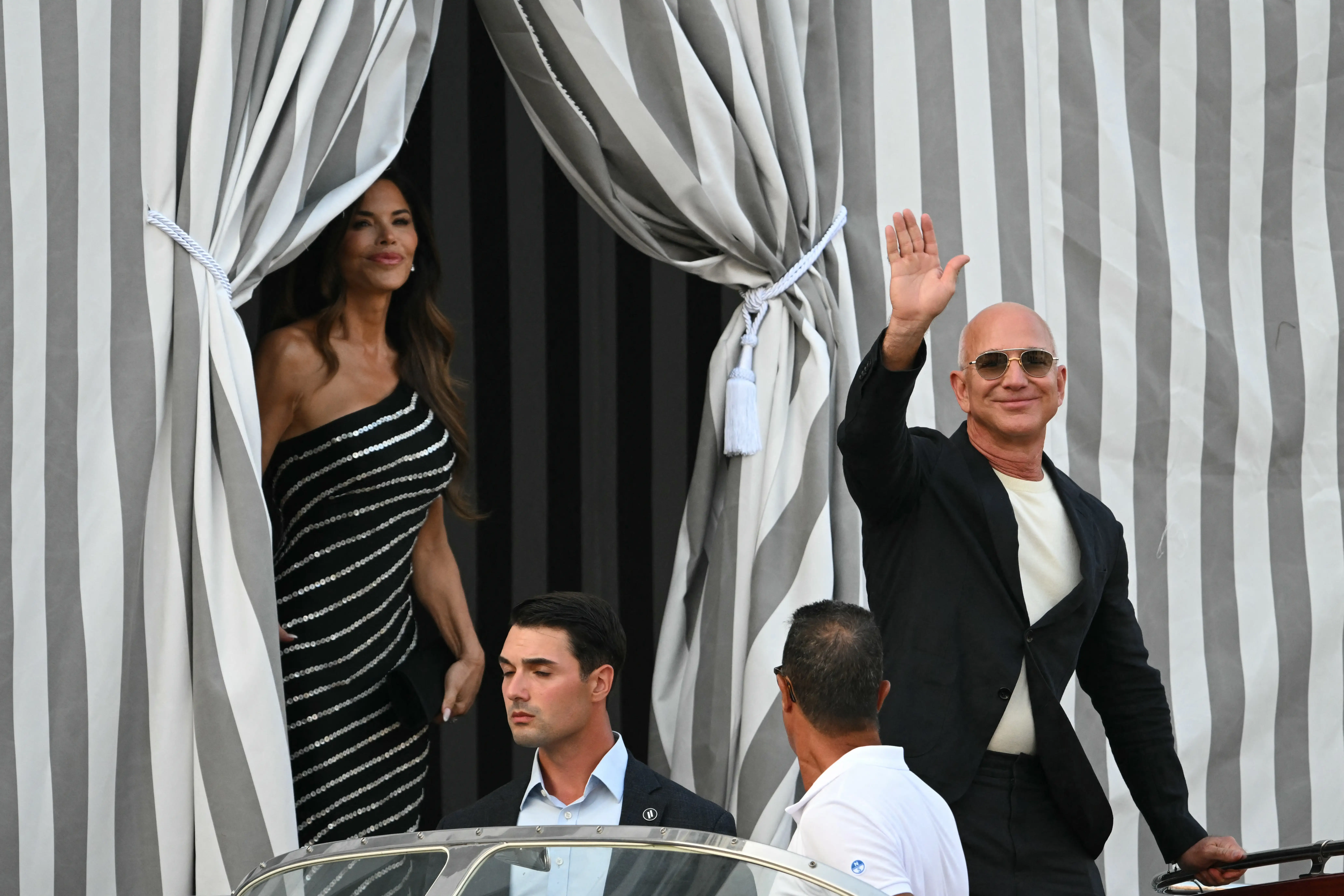 Lauren Sanchez and Jeff Bezos leave a tented area at the Aman Hotel in Venice on June 25, 2025.