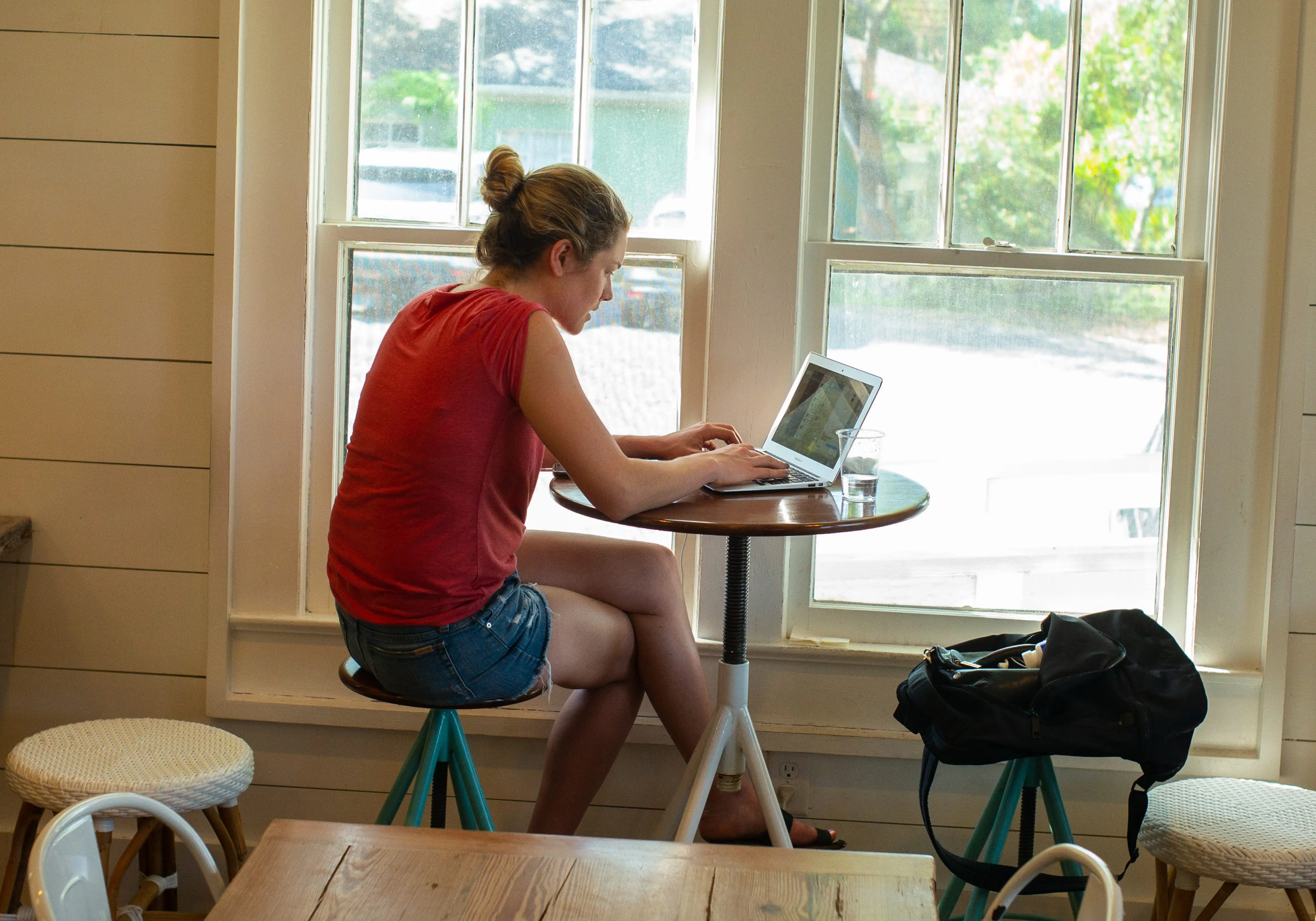 A woman works on a laptop at a coffee shop