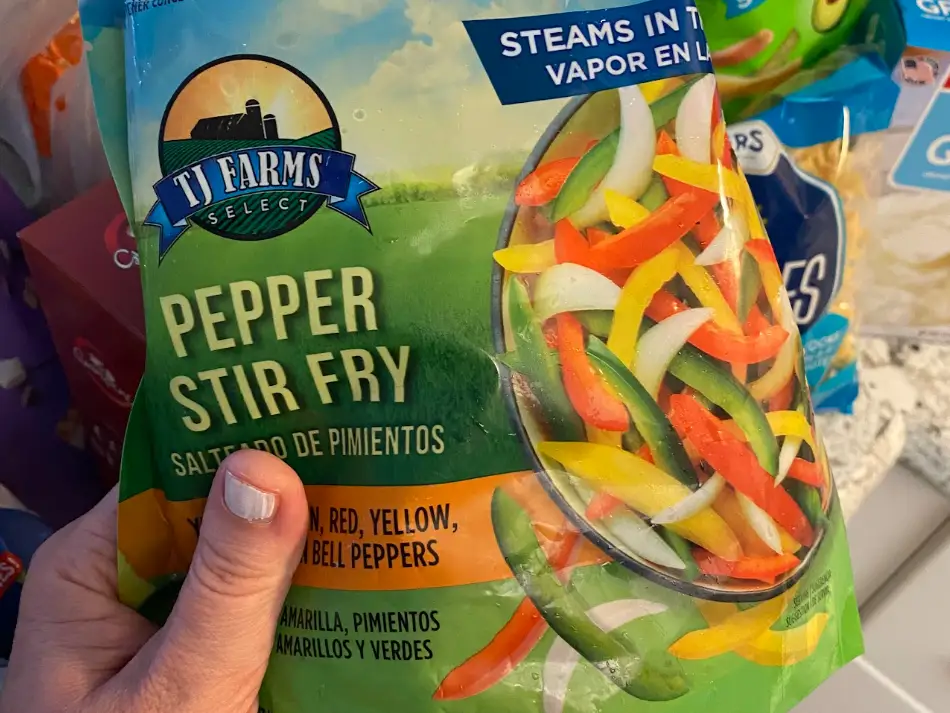 The writer holding a bag of TJ Farms Select pepper stir-fry.