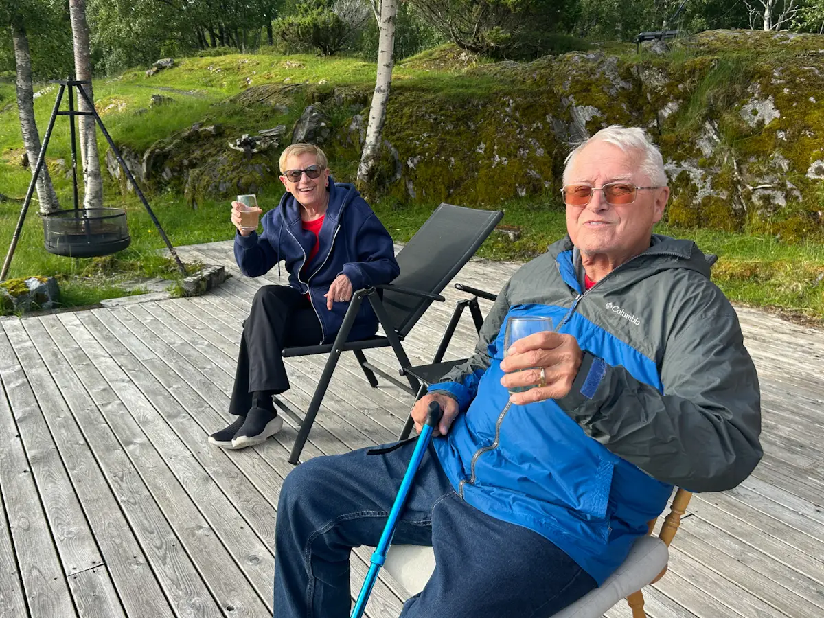 Two people holding drinks on deck