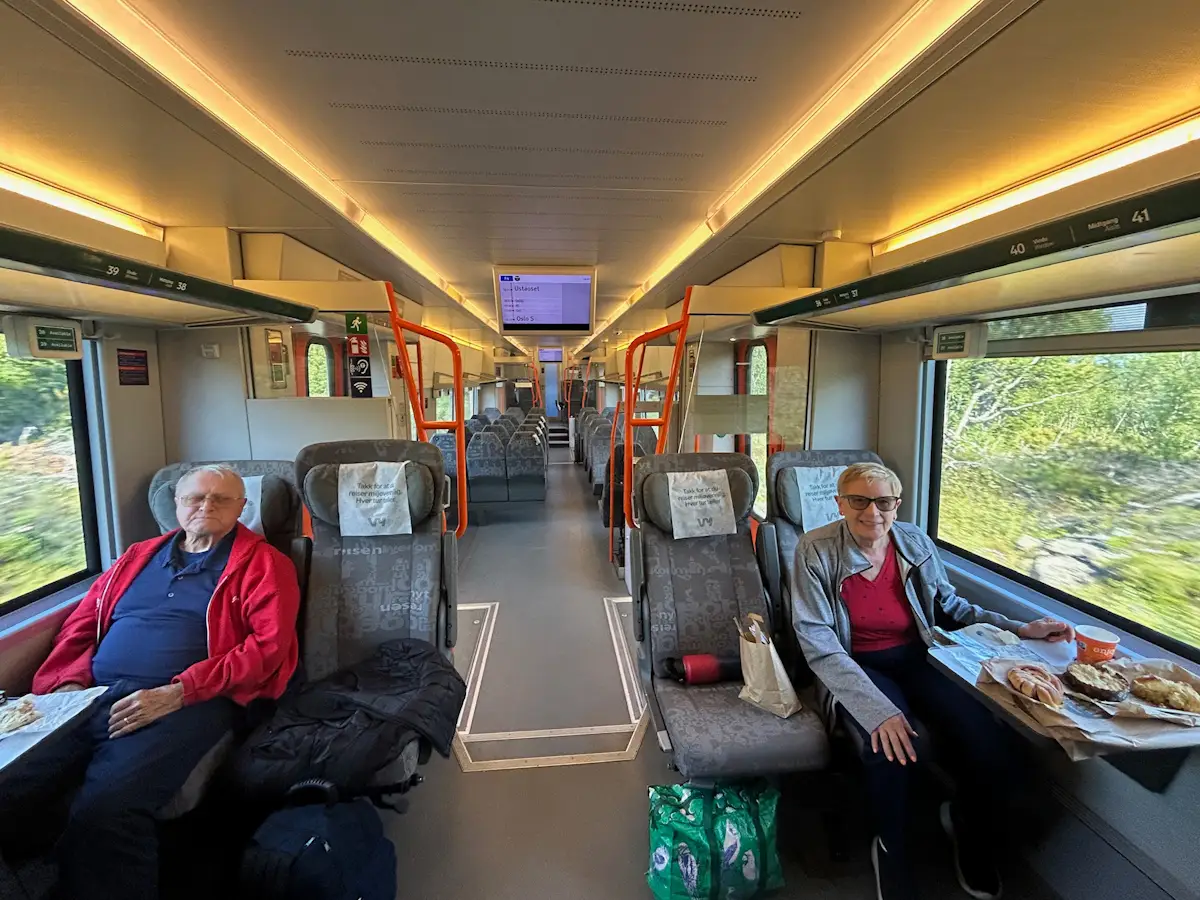 Two older adults sitting on train in Norway