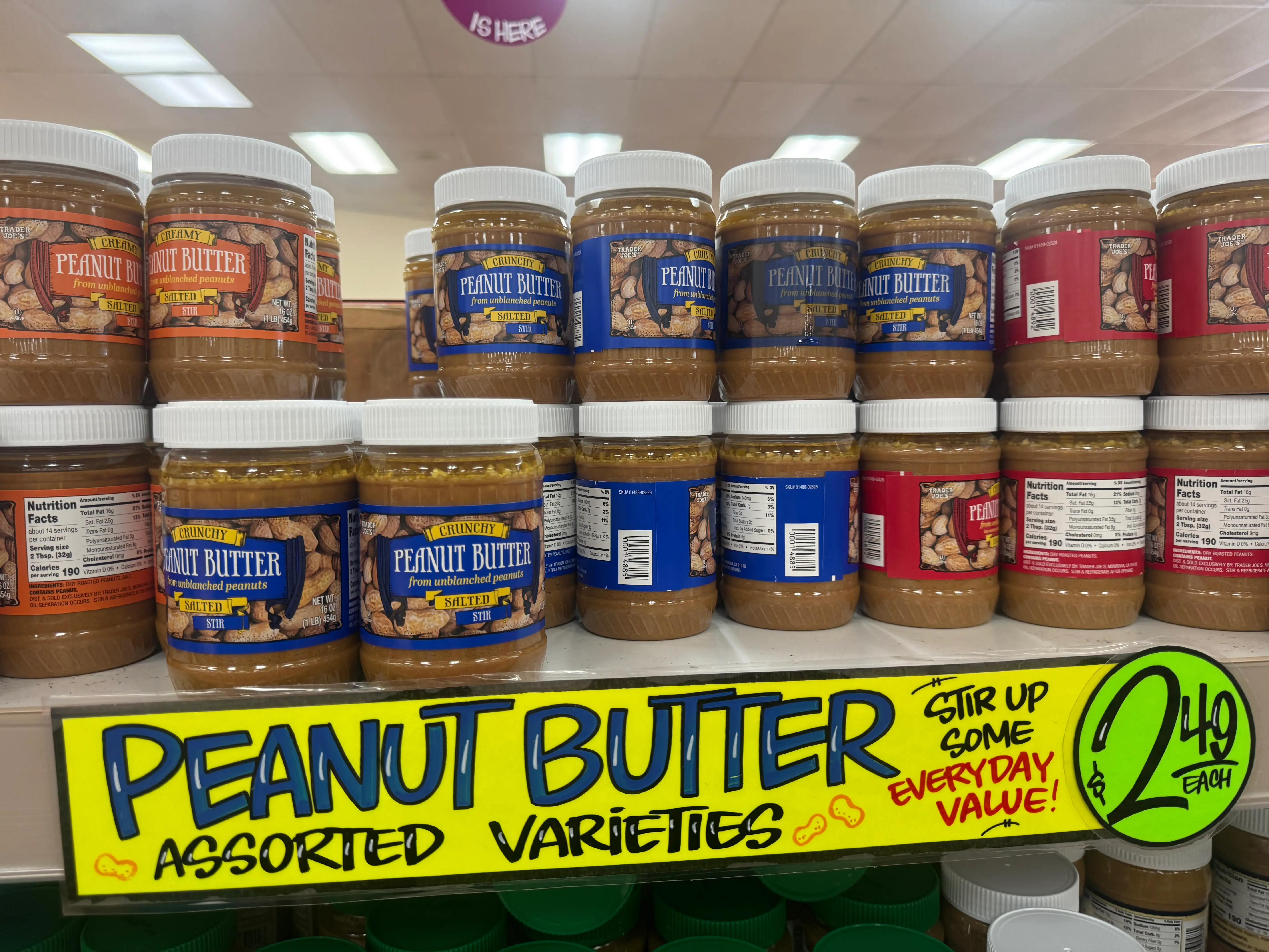 Jars of peanut butter on a shelf at Trader Joe's.