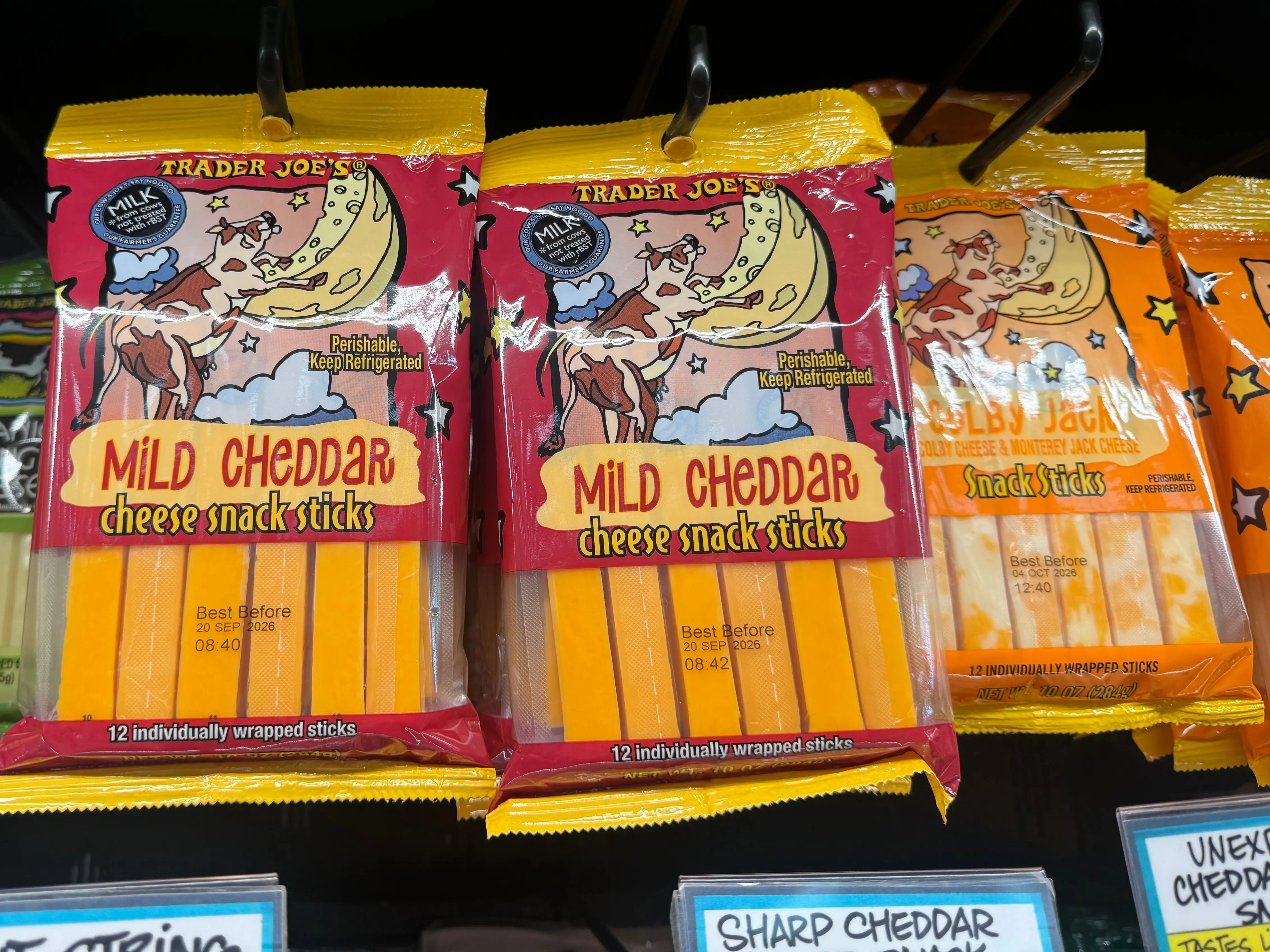 Bags of Trader Joe's mild cheddar cheese sticks.