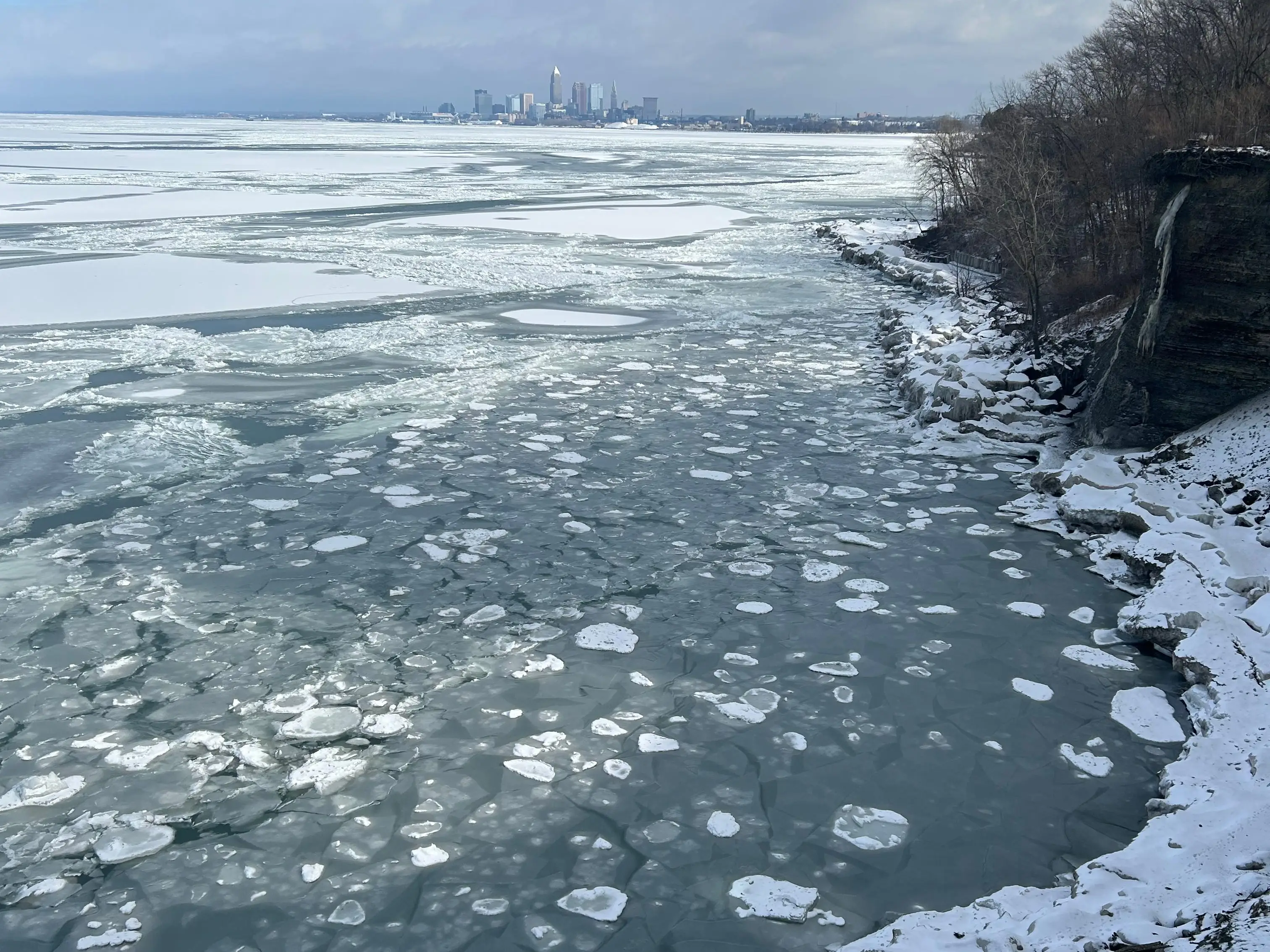 Frozen Lake Erie shoreline with downtown Cleveland visible in the distance.