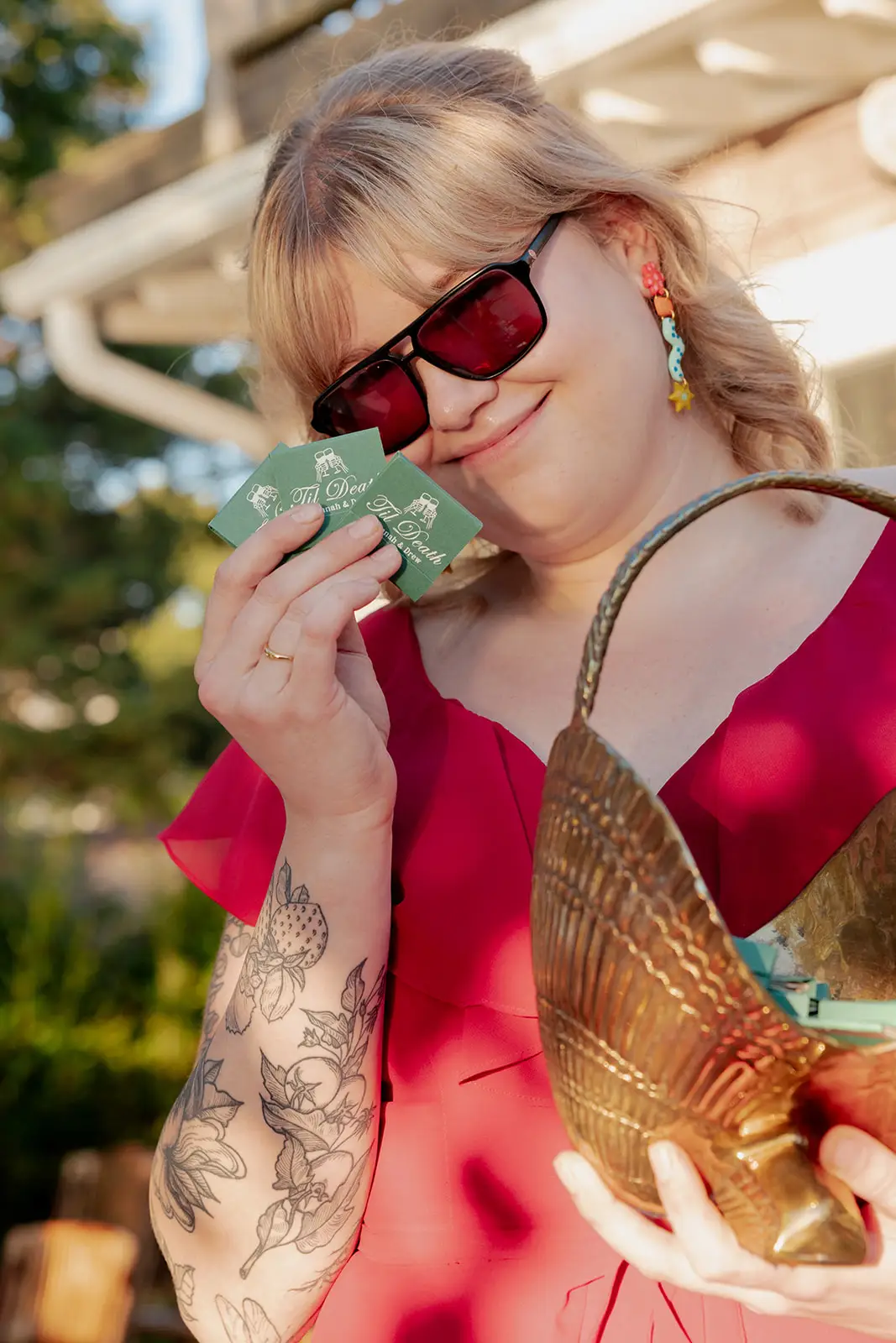 A woman holds up matchbooks at a wedding.