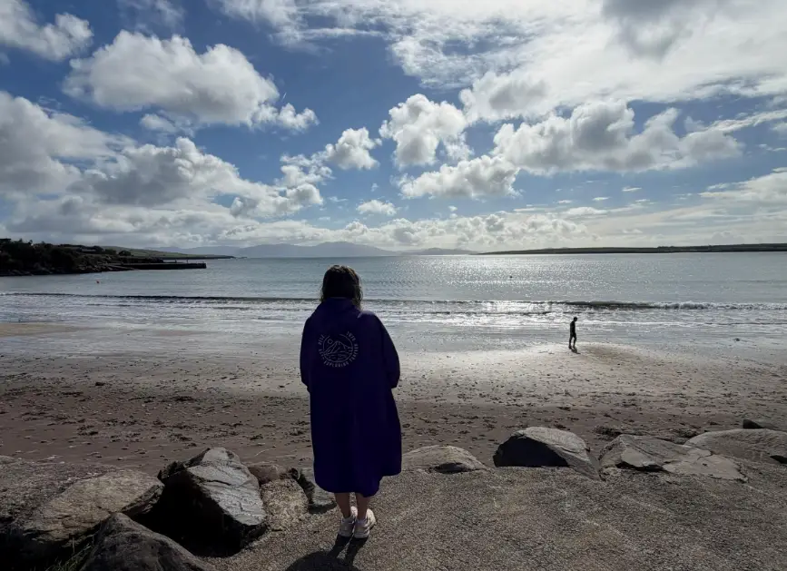 Woman looking out at water on beach