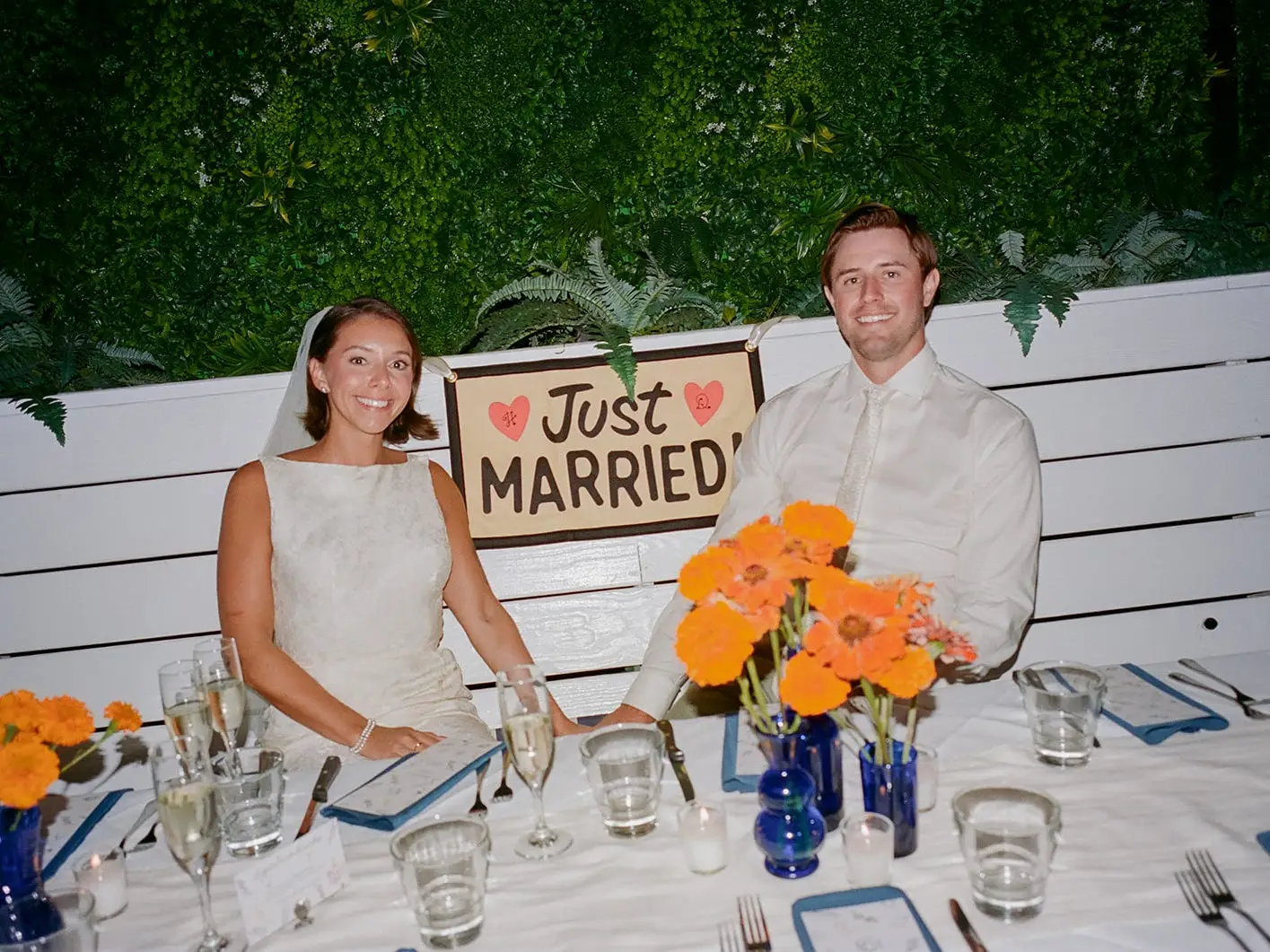 A bride and groom sit at a table with a