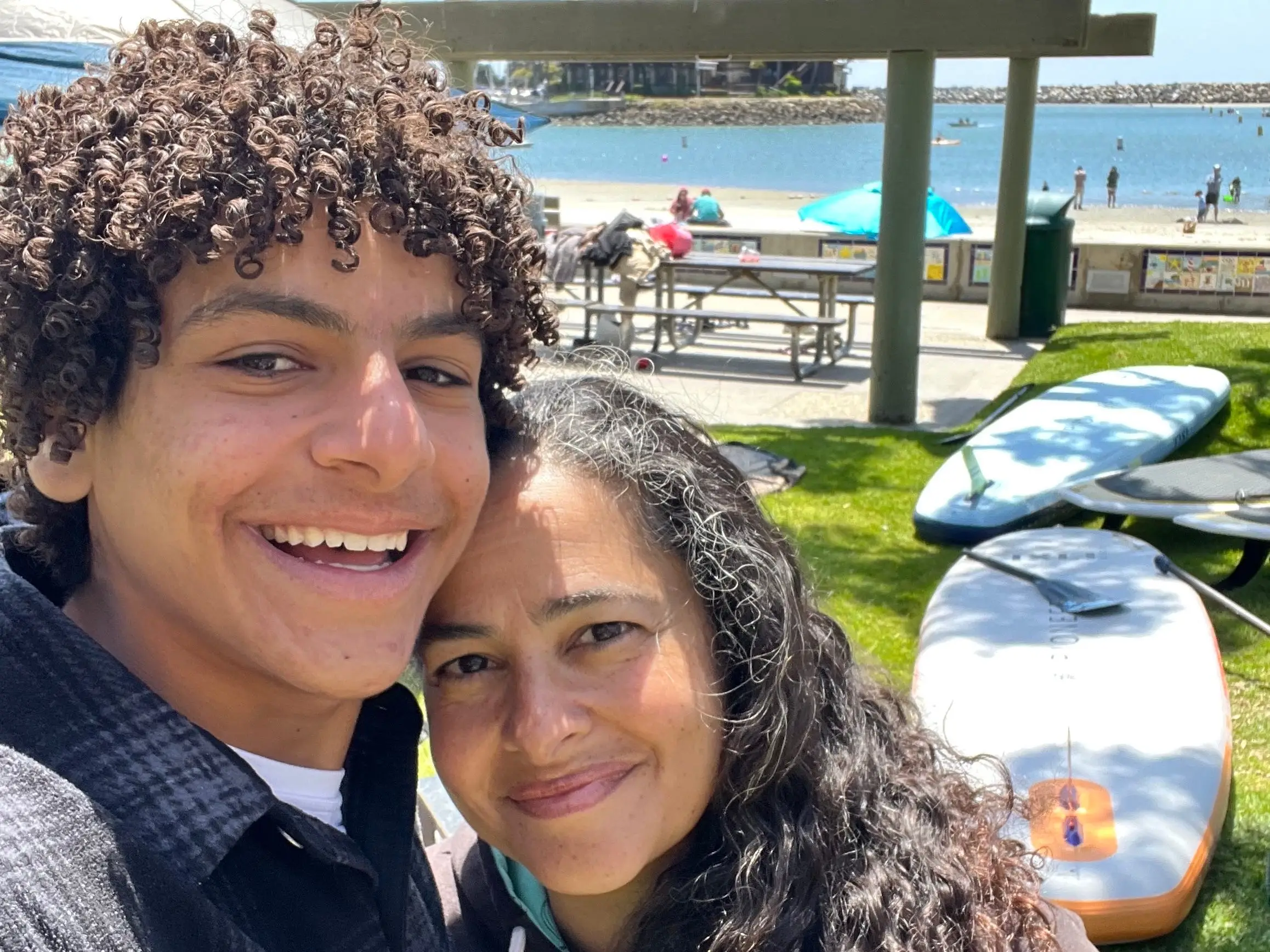 The author poses with her son on a shoreline.