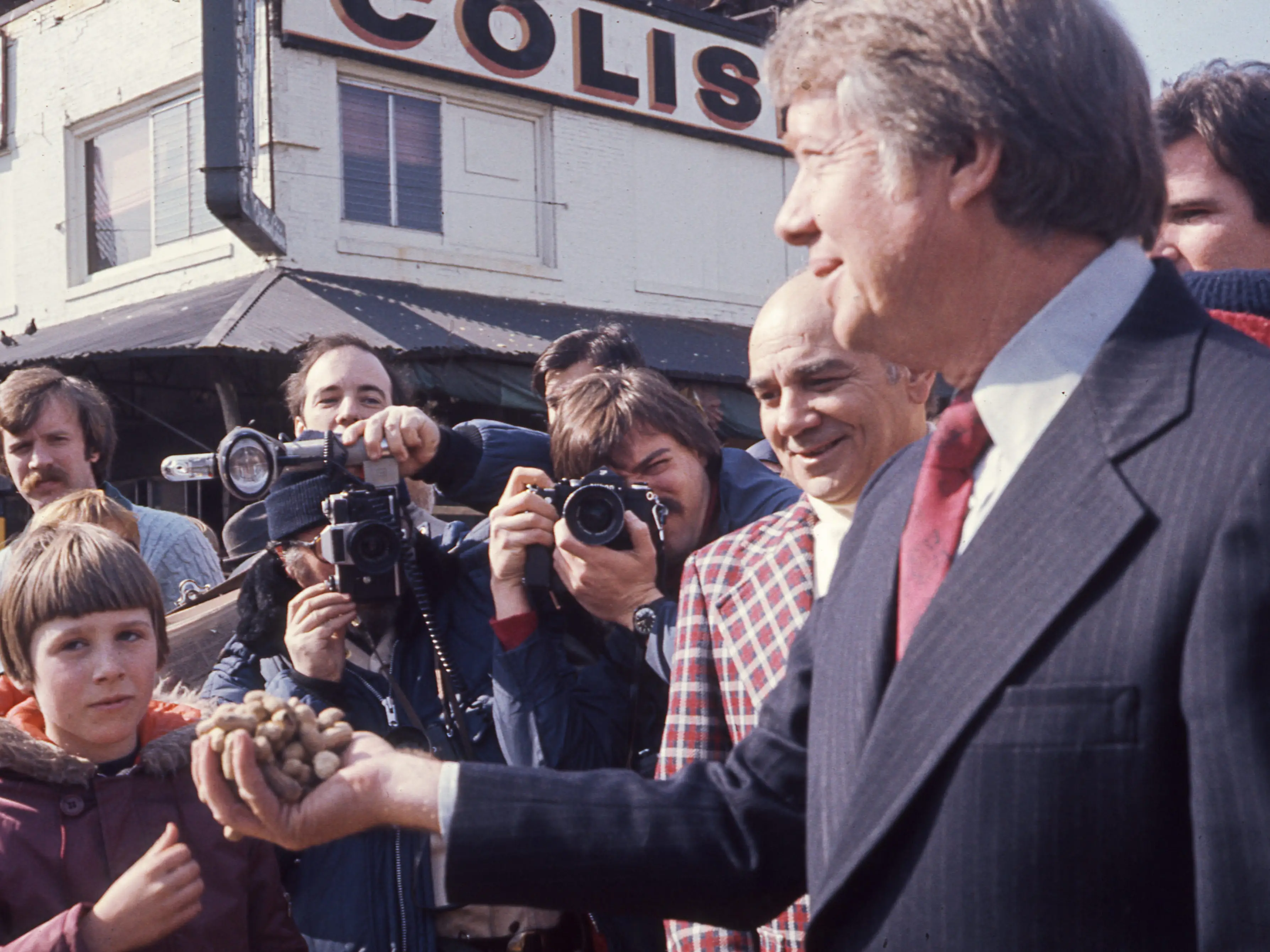 American politician and US Presidential candidate Jimmy Carter holds a handful of peanuts
