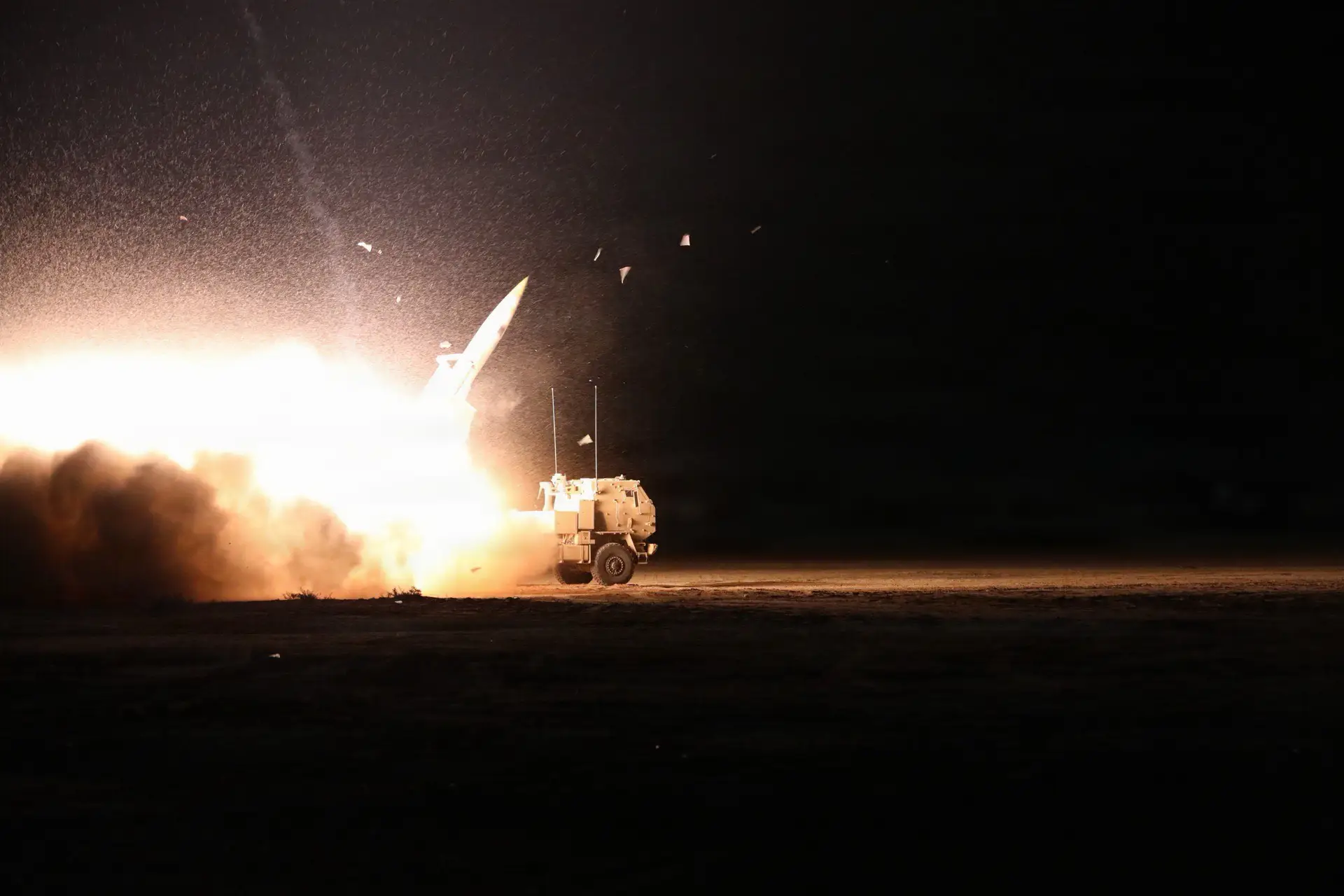 A US High Mobility Artillery Rocket System fires at night.