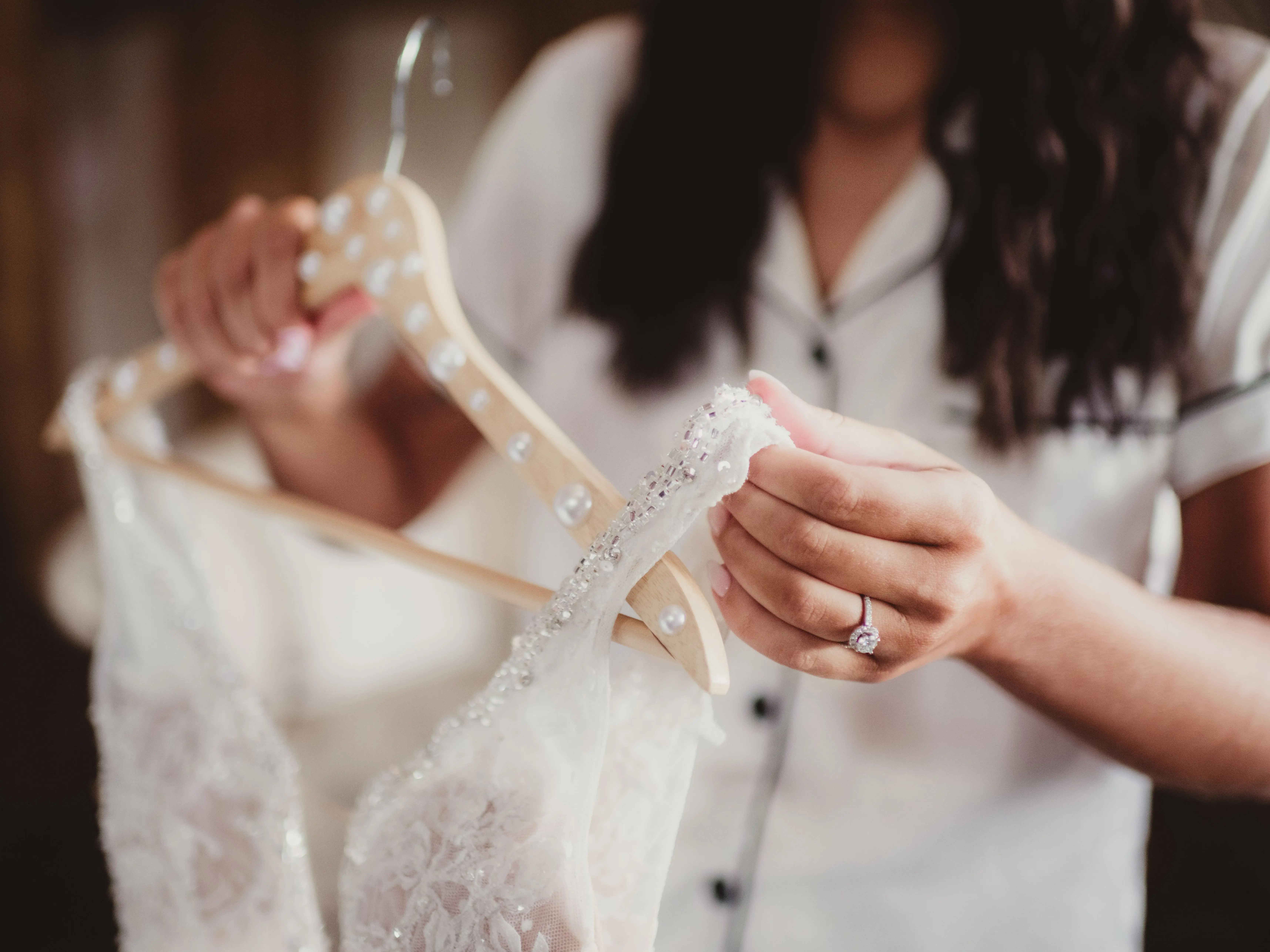 A woman holding the strap on a wedding gown.
