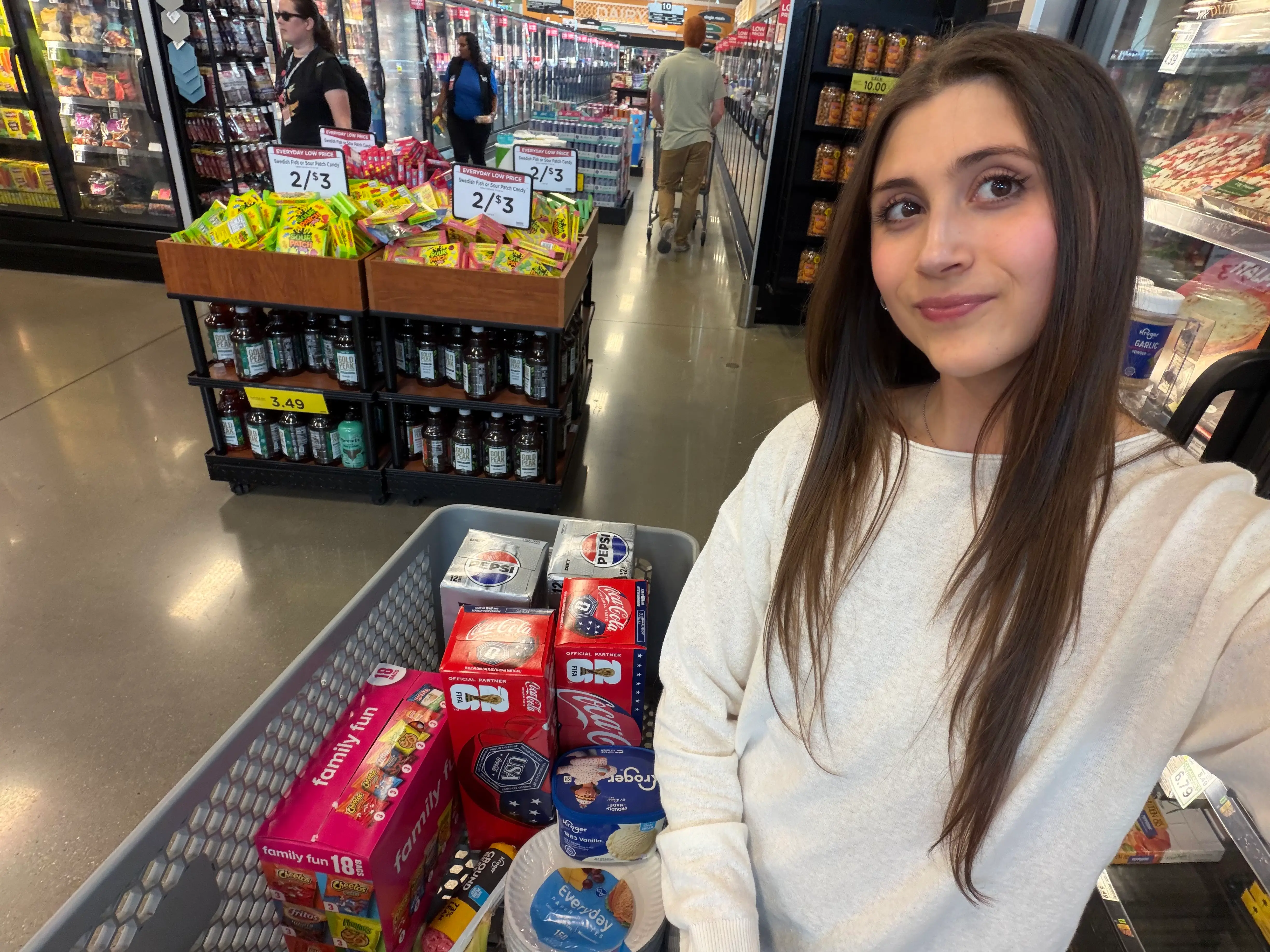 Woman smiling with shopping cart in Kroger
