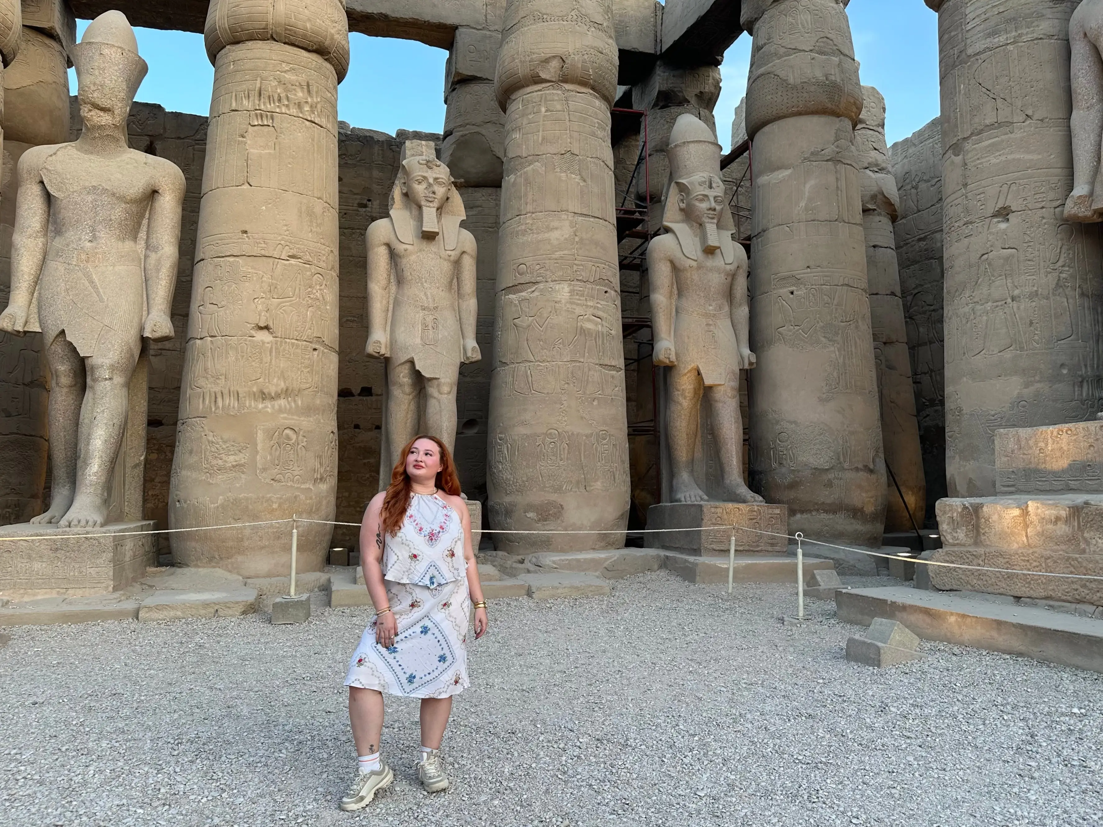 Annmarie poses in front of giant statues at Luxor Temple in Egypt.