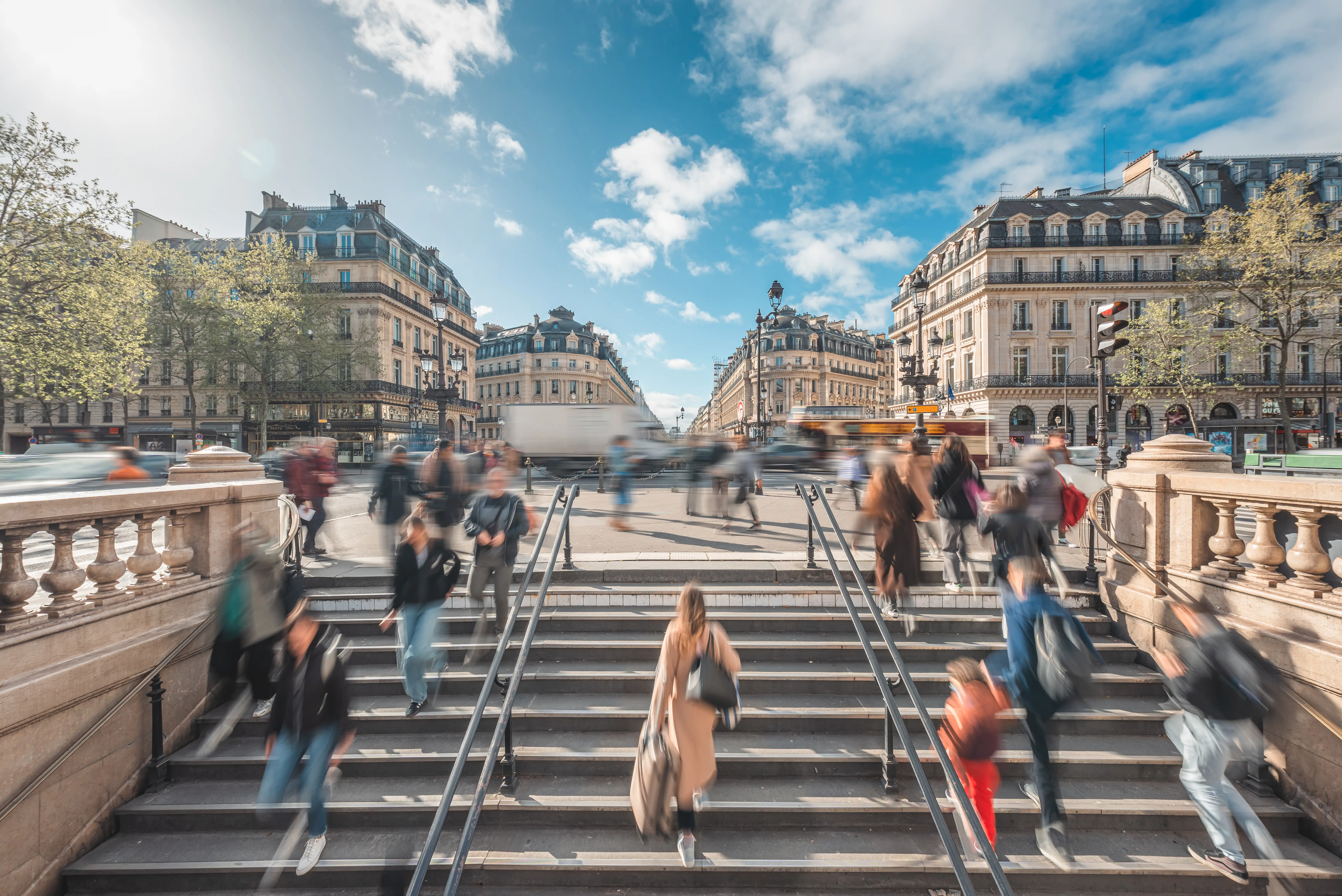 a crowd of people in a scenic city street walking fast with motion blur