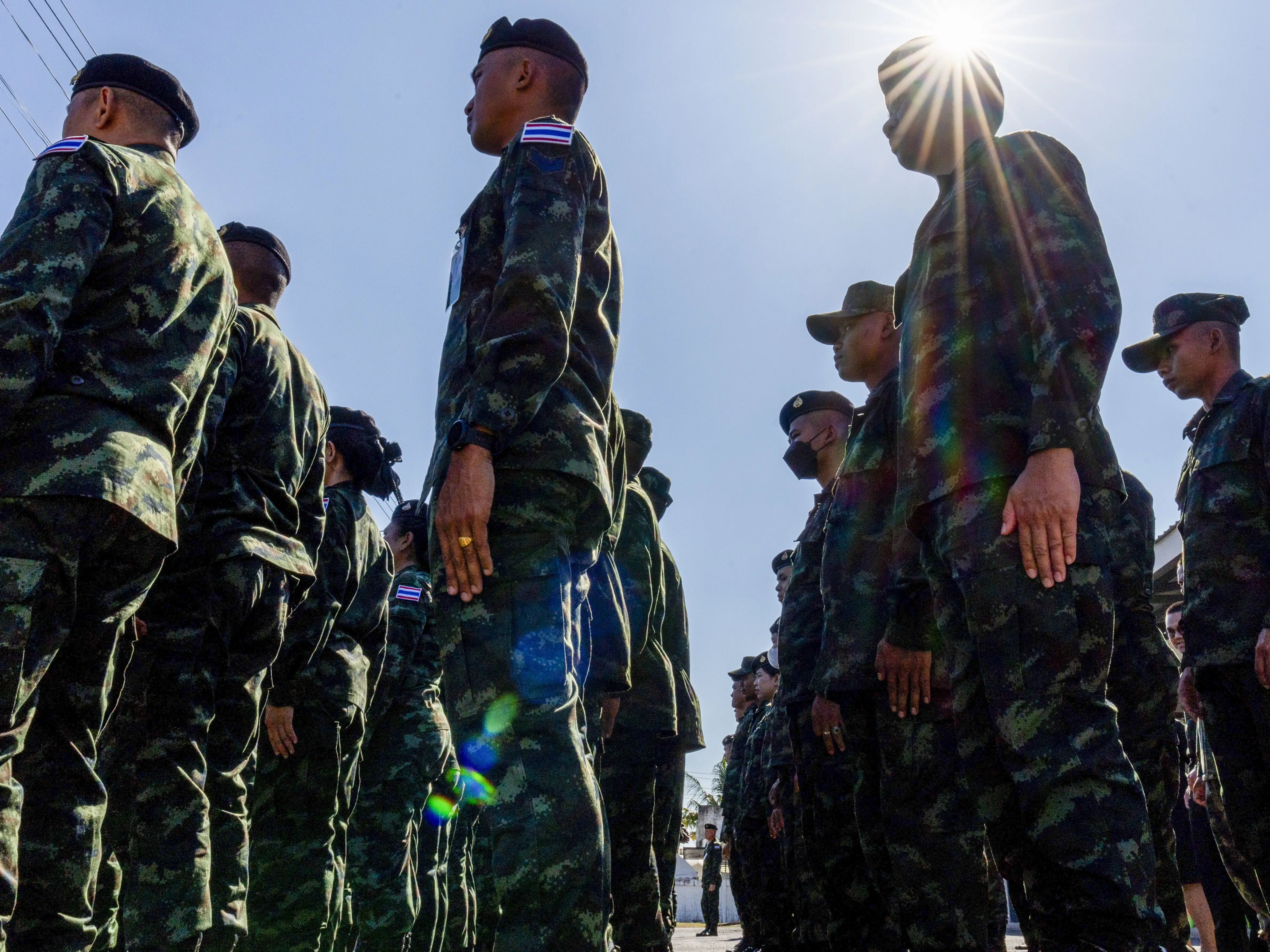 Royal Thai Armed Forces service members stand at attention during a ceremony for two Thai soldiers Sergeant Major Samroeng Klangprakon and Private Phanupat Sausa who were killed in action during combat at hill 350, in Prasat city, Surin province, Thailand on December 21, 2025.