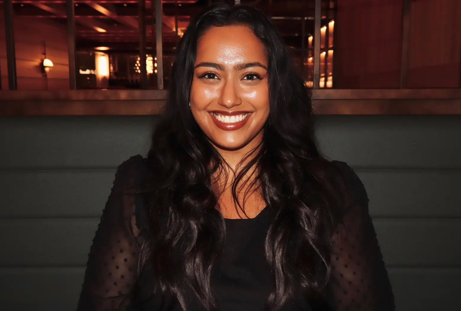 The writer sitting in a black booth in a restaurant in Los Angeles.