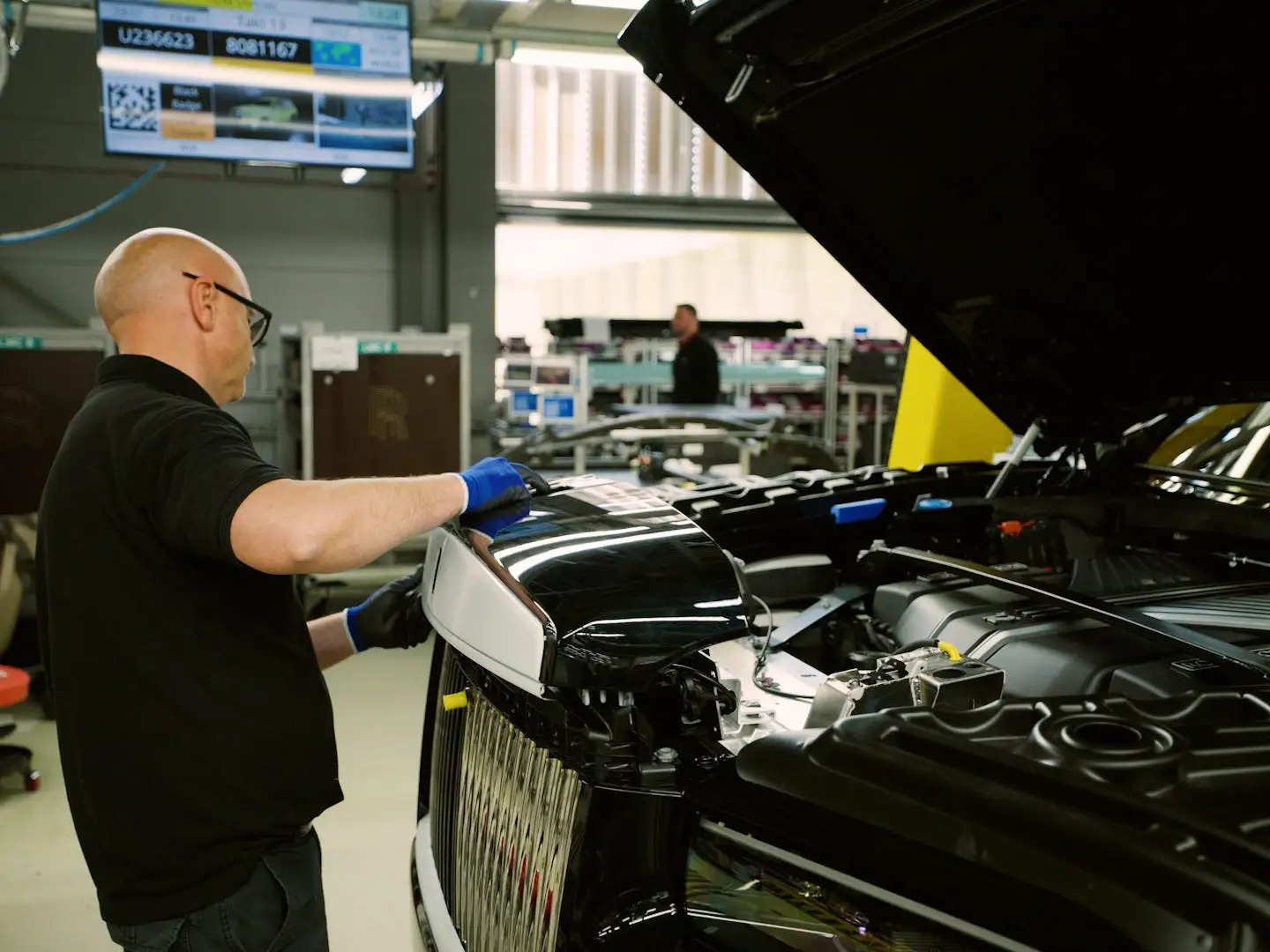 A worker works on the front of a car